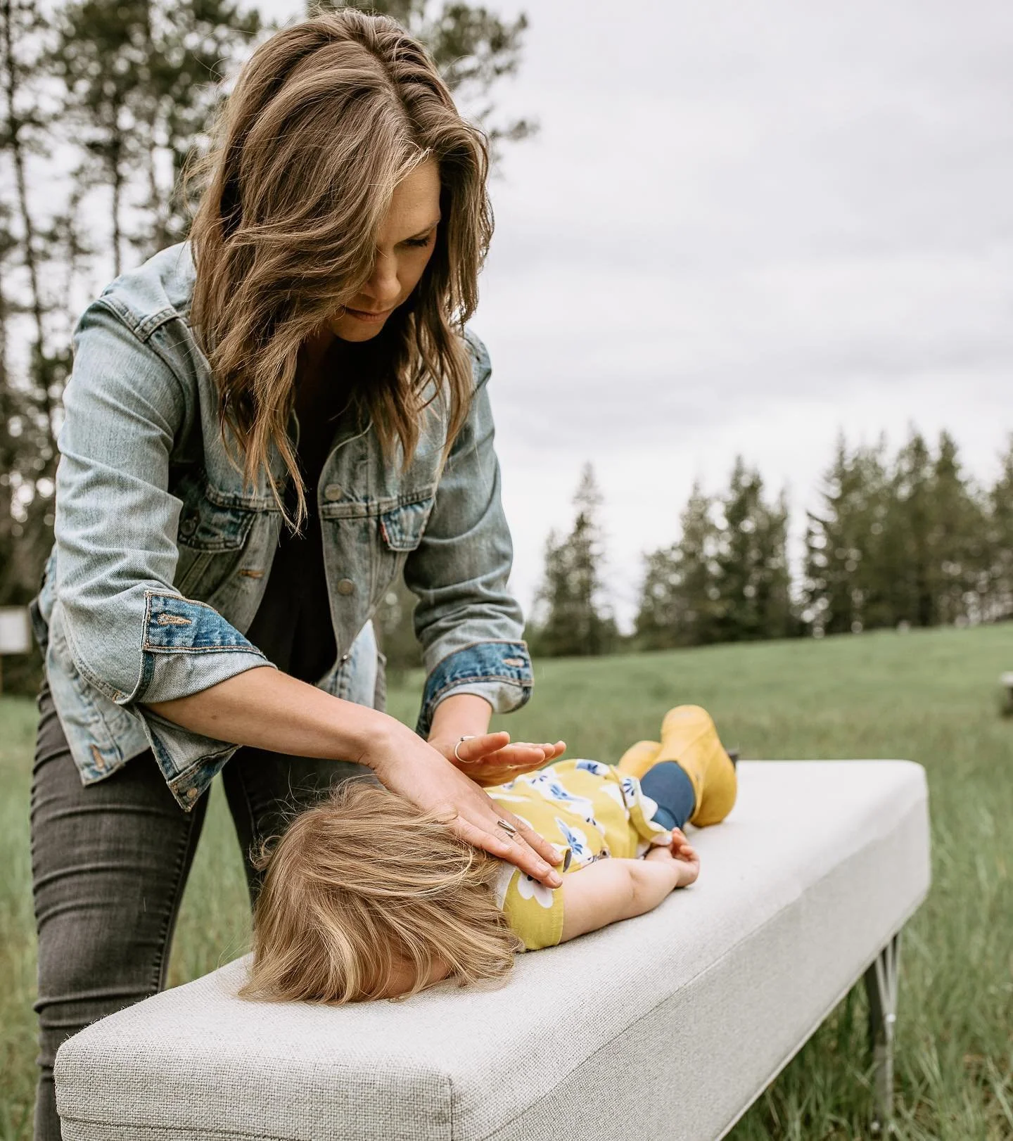 Dr. Jordan Fennelly gently adjusting a female pediatric patient's neck using the Gonstead Method at his practice, Two Sparrows Family Chiropractic, in Whitefish, Montana