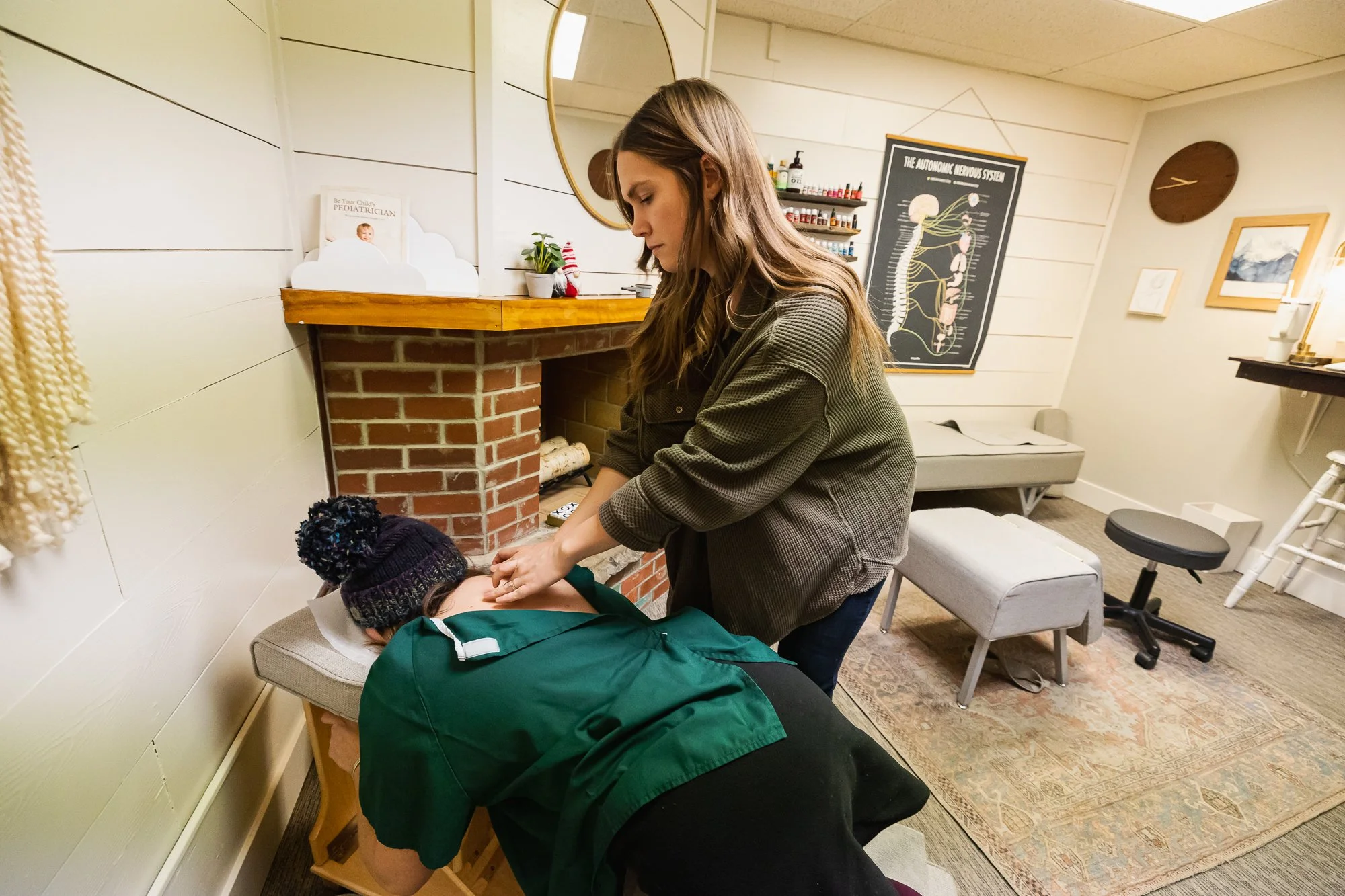 Dr. Jordan of Two Sparrows Chiropractic in Whitefish, MT, providing a chiropractic mid back adjustment on the knee chest, in her office.