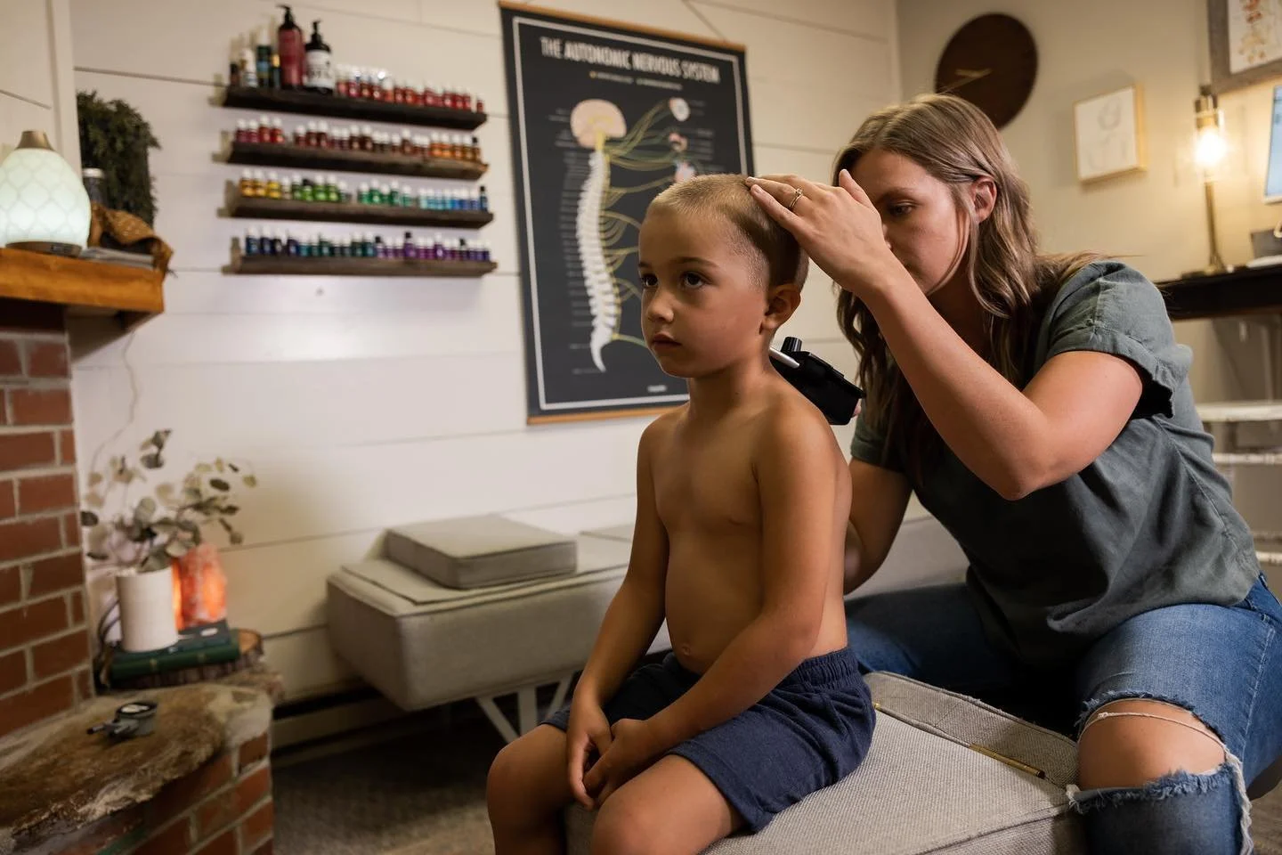 Dr. Jordan of Two Sparrows Chiropractic in Whitefish, MT, performing a chiropractic assessment on a pediatric patient's spine