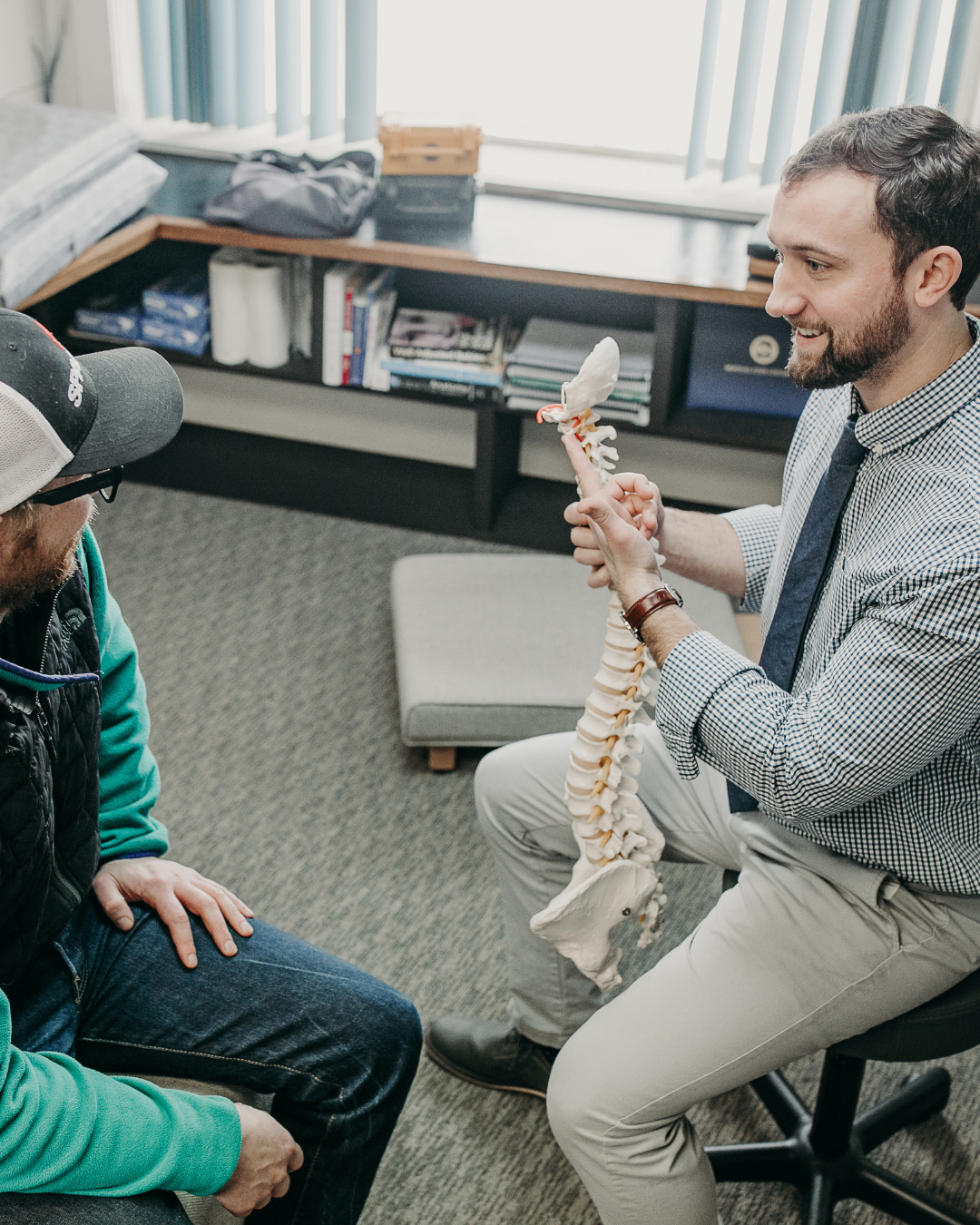 Dr. Peter Fennelly of Two Sparrows Chiropractic in Whitefish, MT is explaining a spine model to a patient