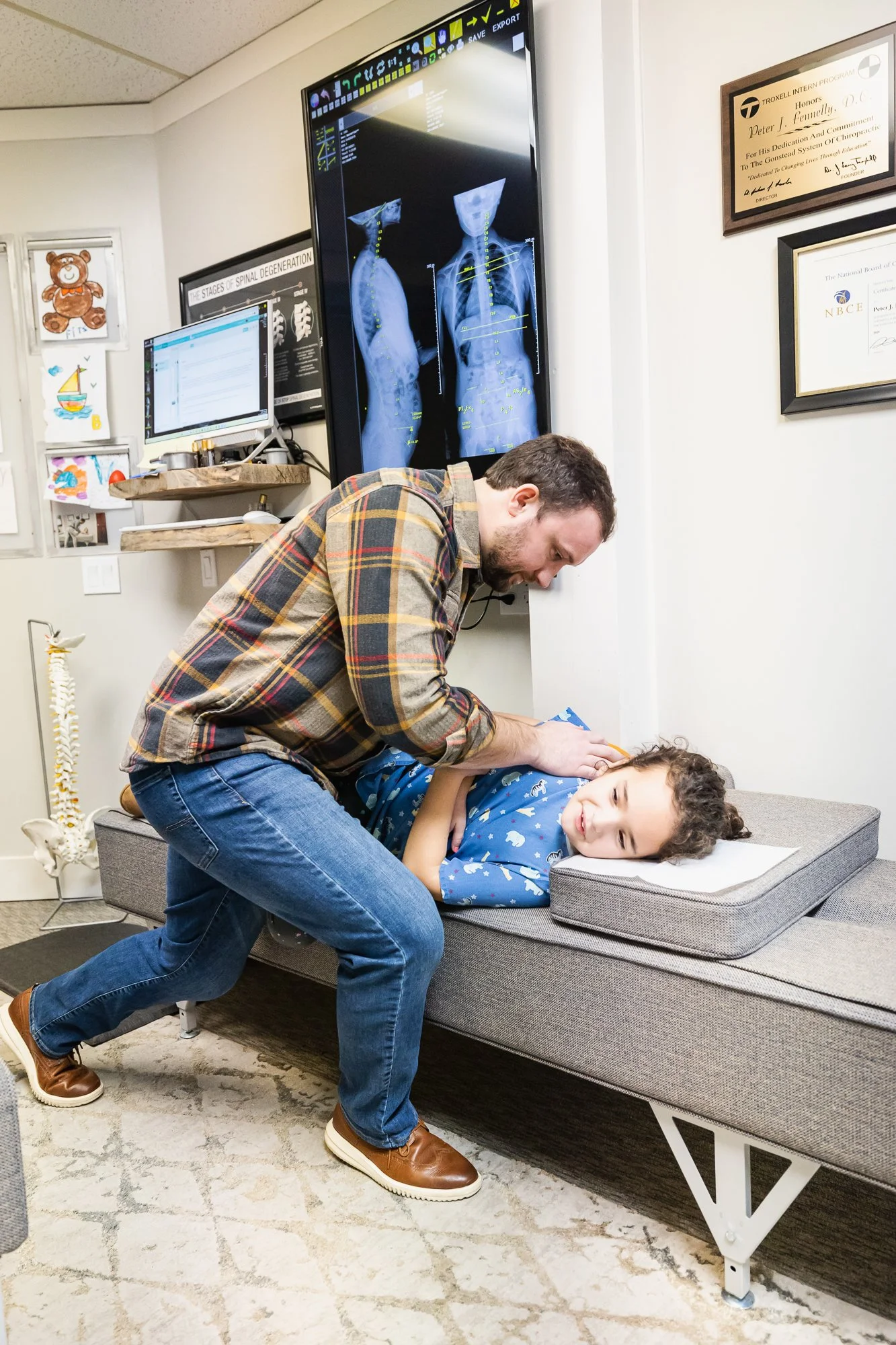 Dr. Peter Fennelly adjusting a female pediatric patient's low back using the Gonstead Method at his practice, Two Sparrows Family Chiropractic, in Whitefish, Montana