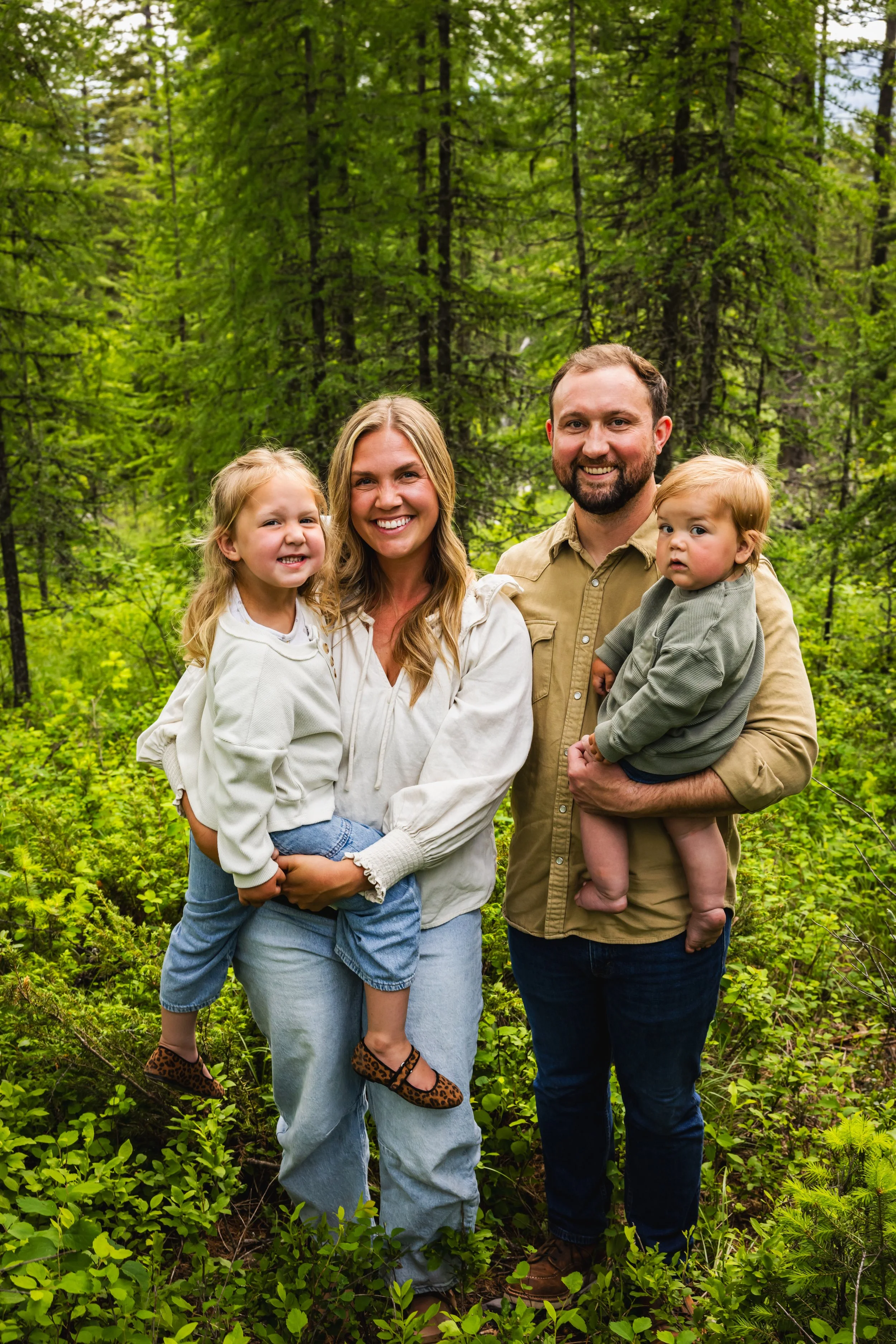 Dr. Jordan Fennelly and Dr. Peter Fennelly of Two Sparrows Family Chiropractic in Whitefish, Montana holding both of their small children in a family photo.