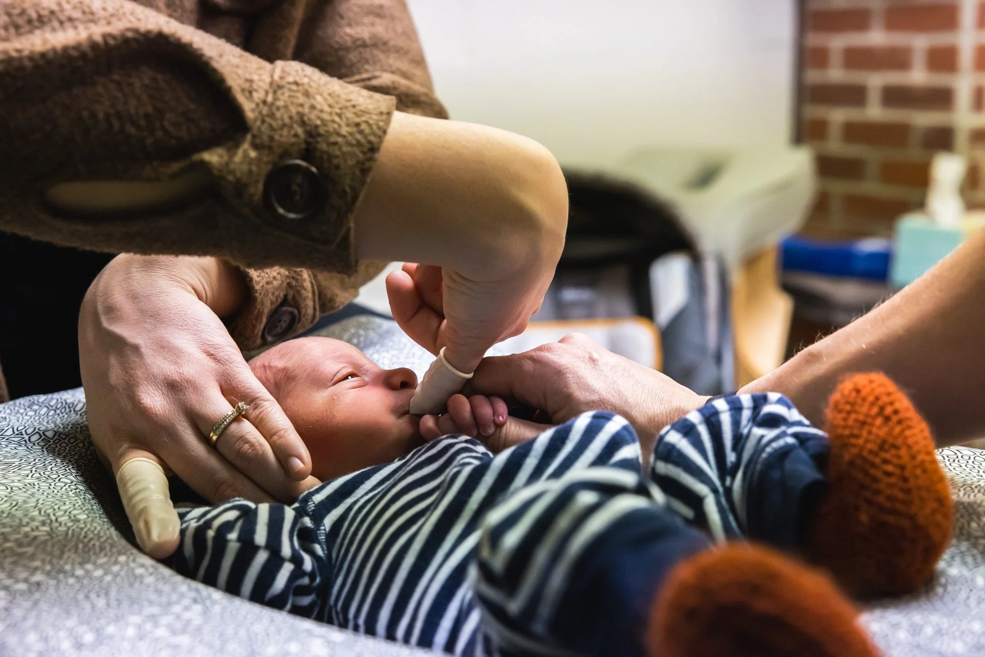 Close-up of a newborn baby receiving a palate assessment from Dr. Jordan Fennelly in the office of Two Sparrows Family Chiropractic