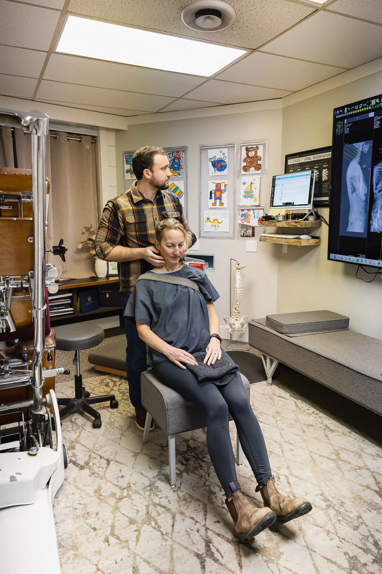 Dr. Peter Fennelly adjusting a physical therapist for postpartum muscle stiffness from breastfeeding, he is assessing the quality of motion in her cervical spine (neck) 
