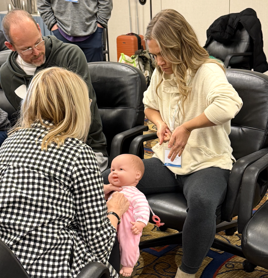 Dr. Jordan of Two sparrows in whitefish, montana, is pictured getting training and ceritifications in newborn chiropractic adjustments with Claudia Anrig