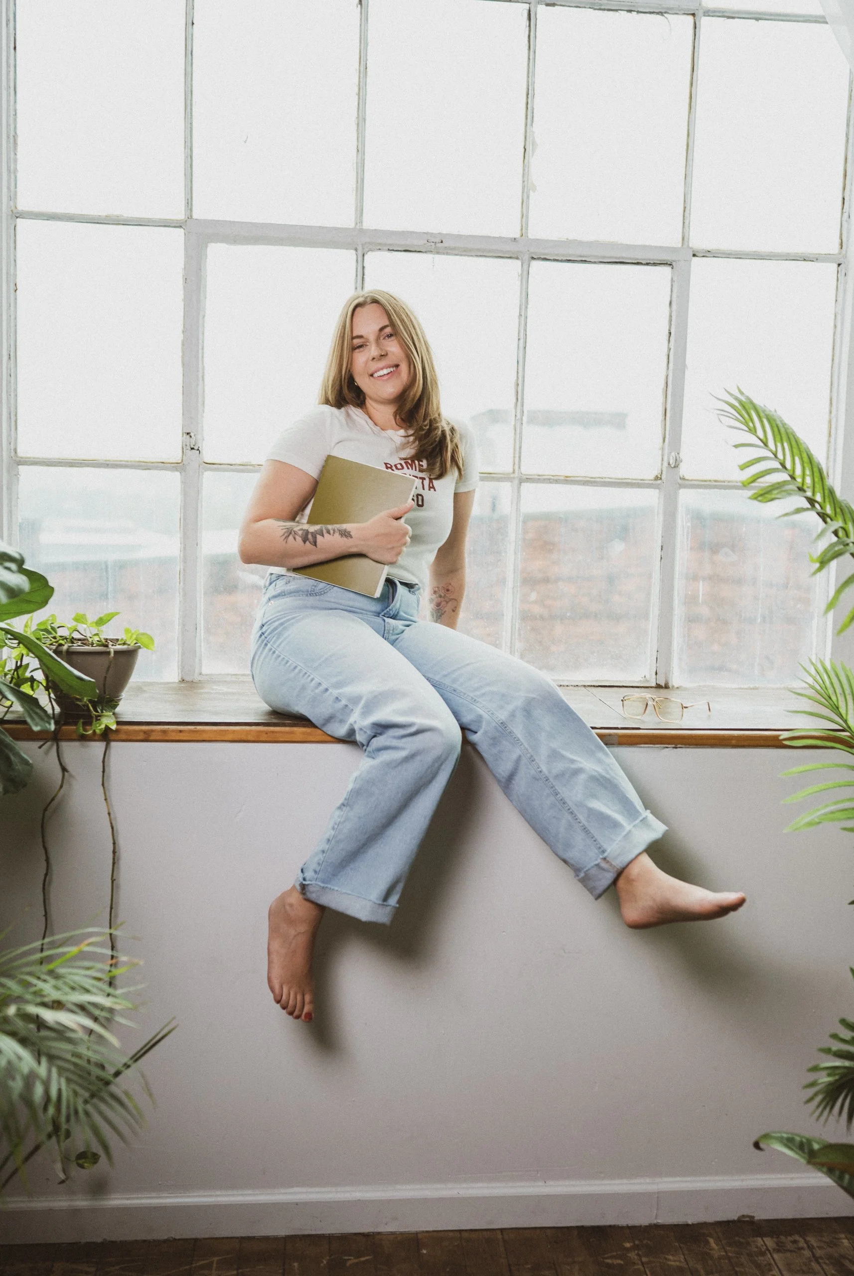 Owner of chartreuse studio holding green notebook