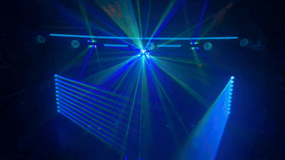 Blue and green laser fans spread beneath a lighting truss while overhead lights glow through haze.