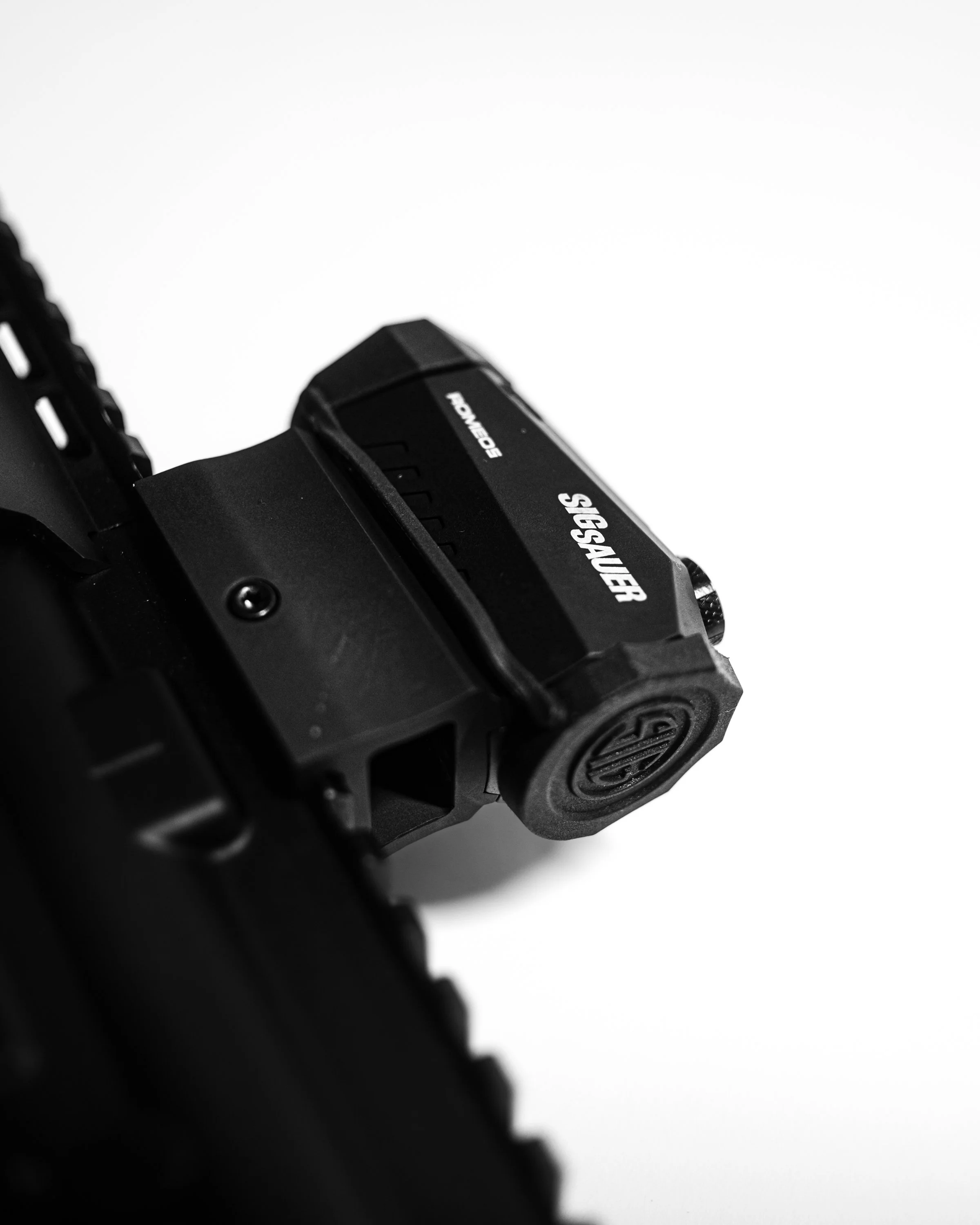 Close-up view of a black power tool with text that says 'POWER RACER' on it, against a white background. Sig Sauer.