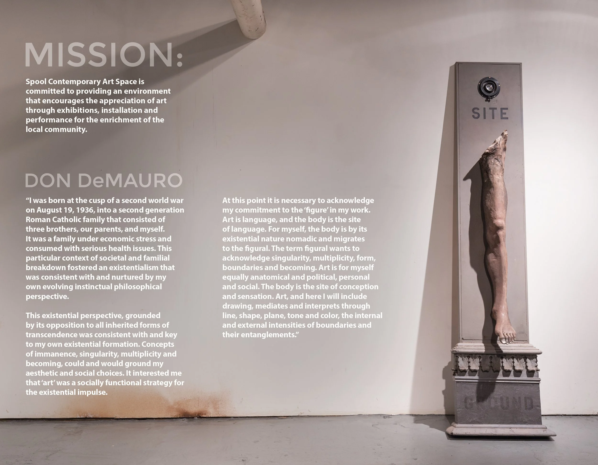 Museum exhibit wall featuring text about the artist Don DeMauro and his artistic philosophy, alongside a classical sculpture of a human figure from the waist down on a pedestal.