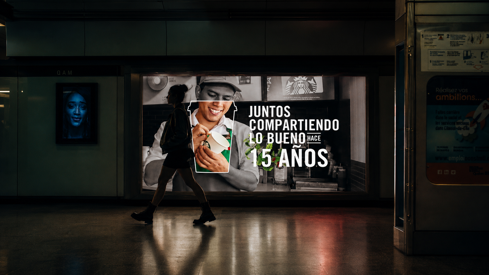 A person walking past a Starbucks advertisement in a subway station, celebrating 15 years of sharing good times.