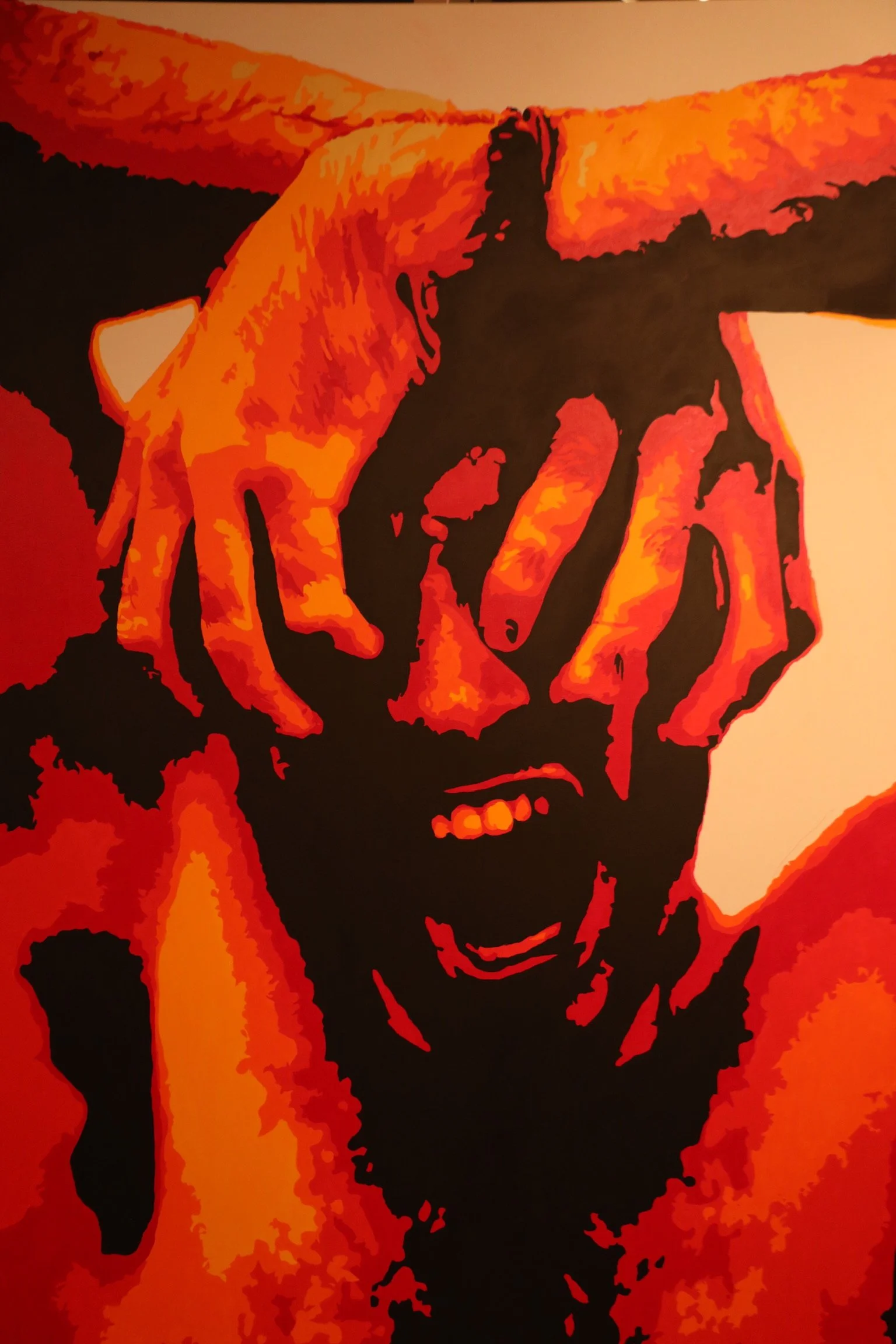 An artistic, stylized portrait of a person with dreadlocks, smiling, painted in shades of red, orange, and black.