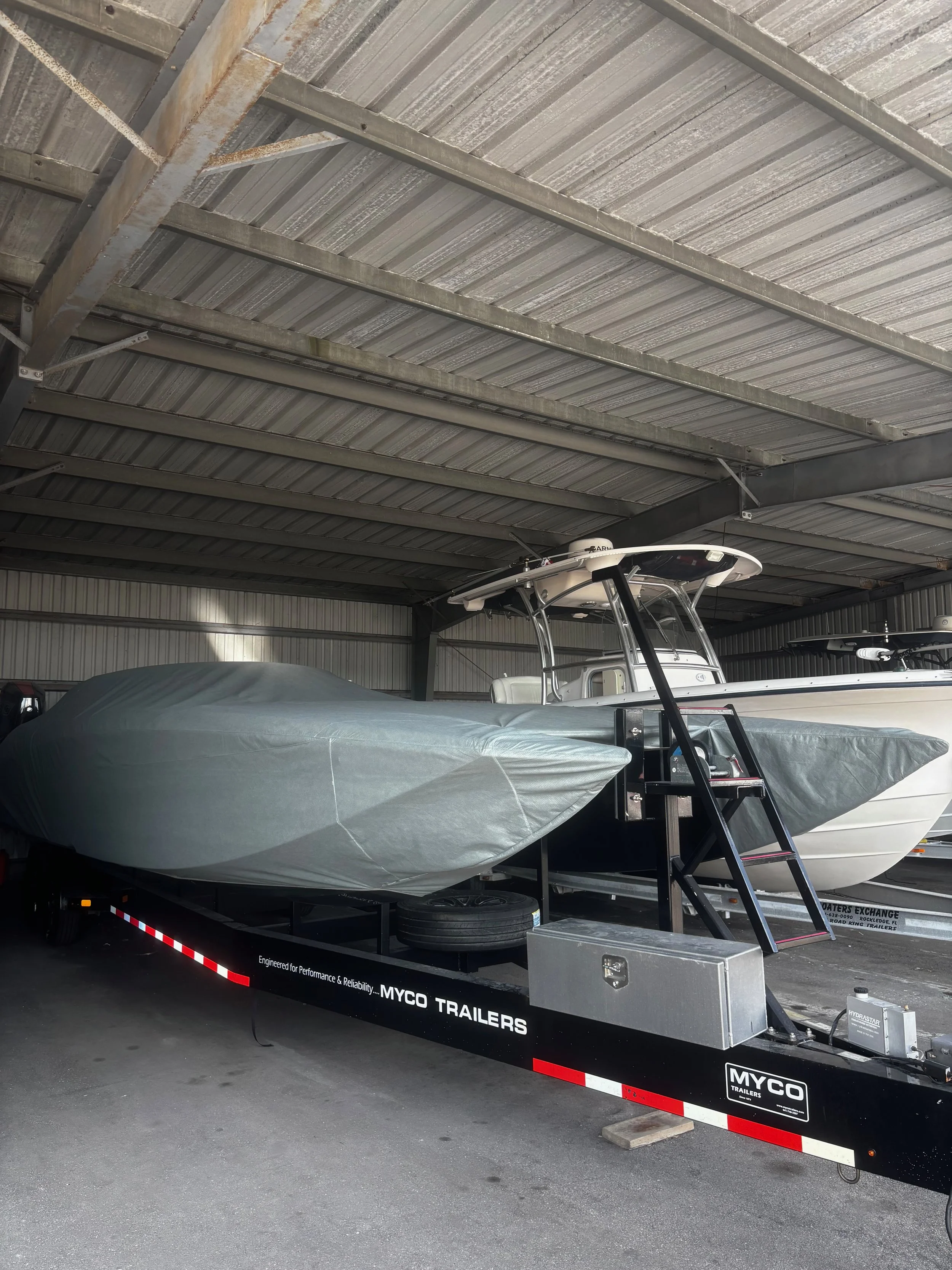 A custom race boat covered with custom-fitted gray cover.