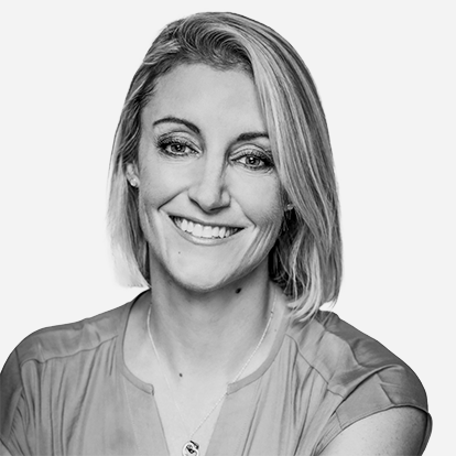 Black and white portrait of a smiling woman with shoulder-length hair, wearing a short-sleeved blouse.