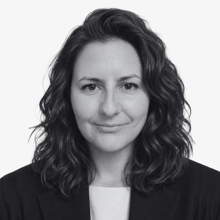 Black and white portrait of a woman with wavy shoulder-length hair, wearing a blazer