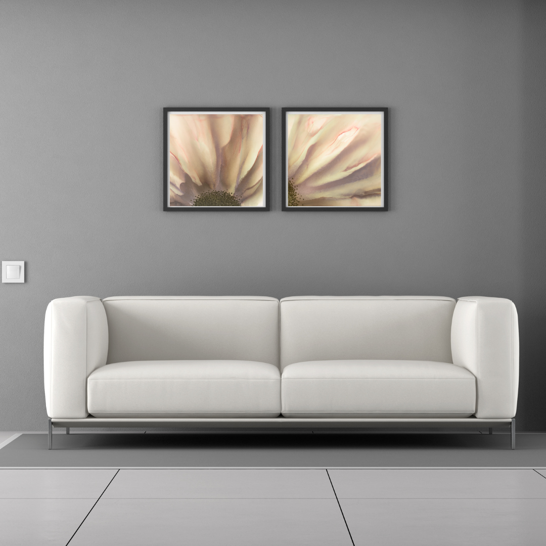 White sofa against a gray wall with two coordinated framed botanical fine art prints displayed above it.
