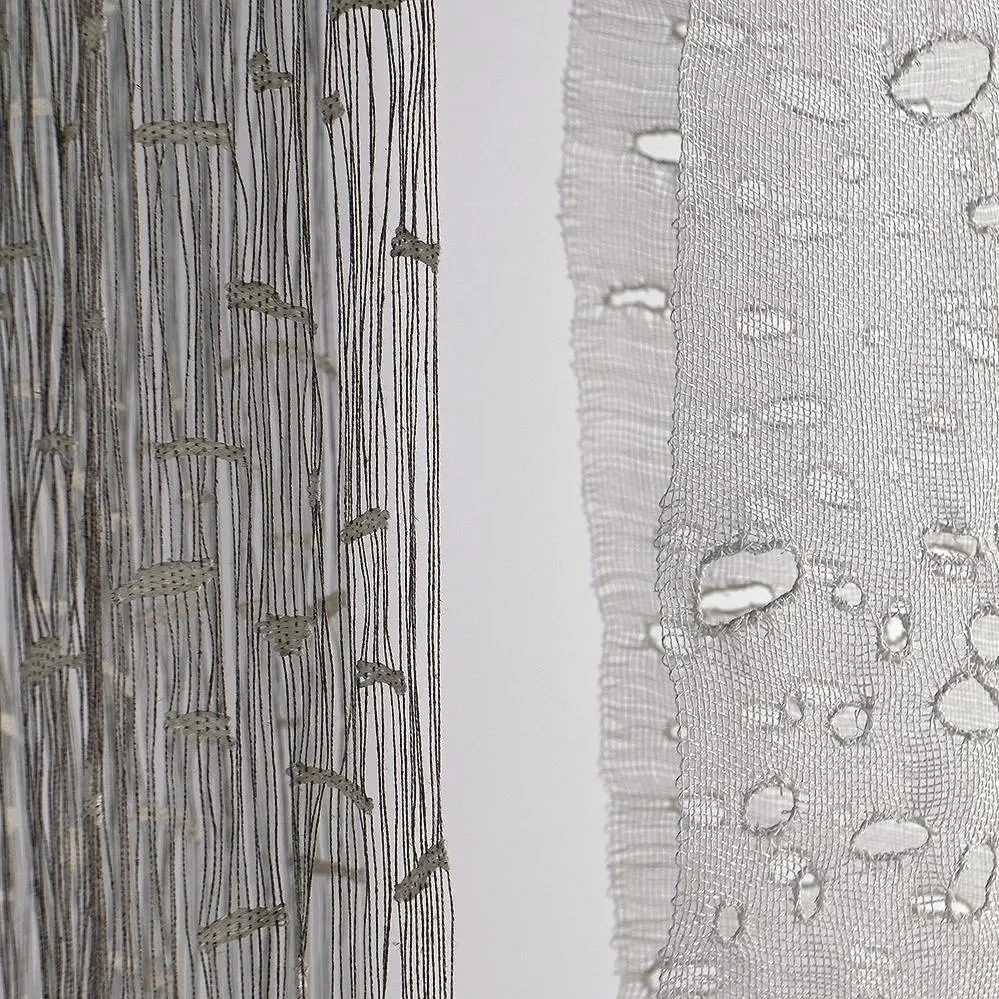 Close-up of two pieces of fabric with different textures, one with embroidered stripes and the other with holes and mesh pattern.