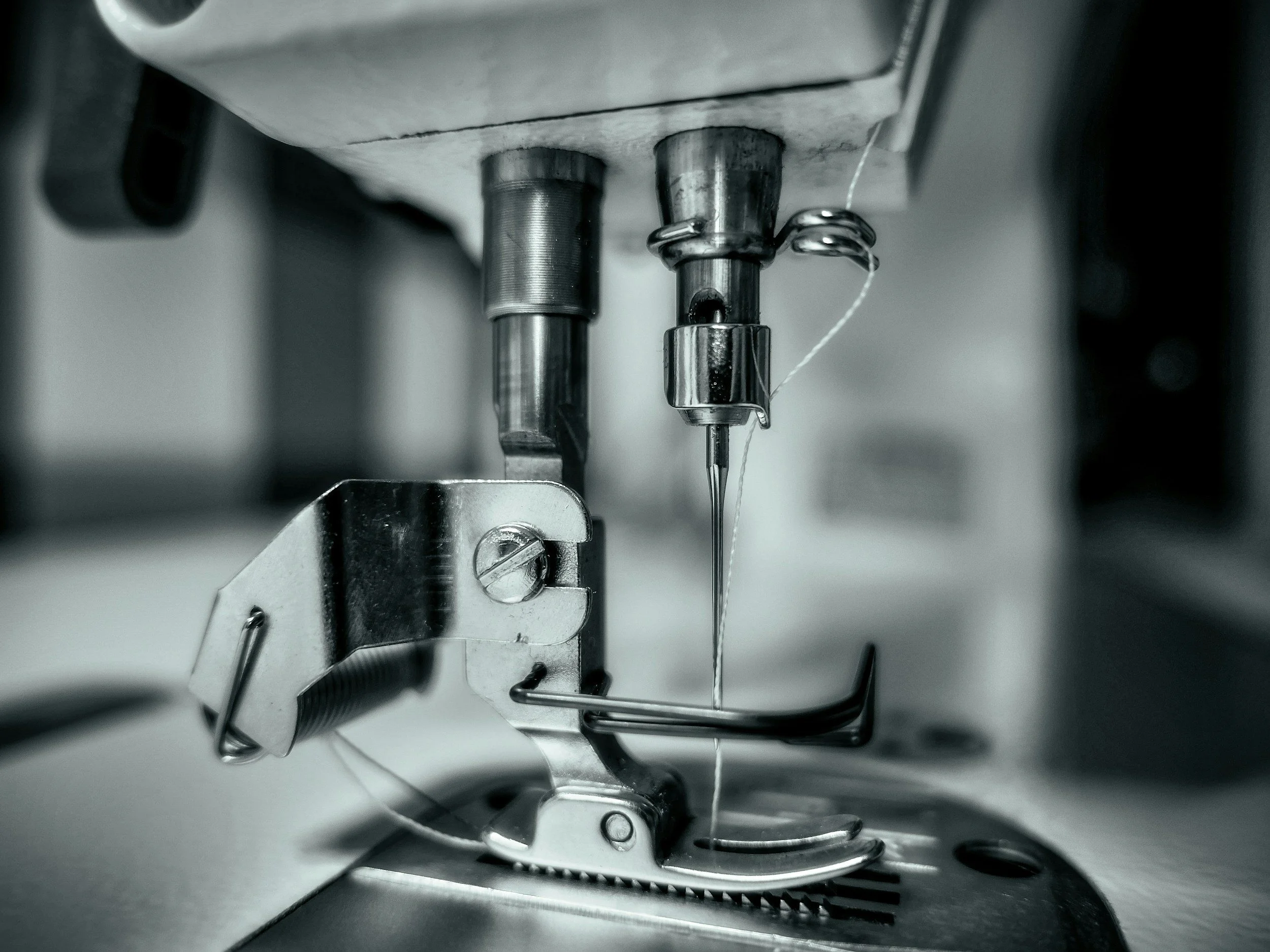 Close-up of industrial or mechanical components, including metal parts, screws, and wiring, possibly inside a machine or device.