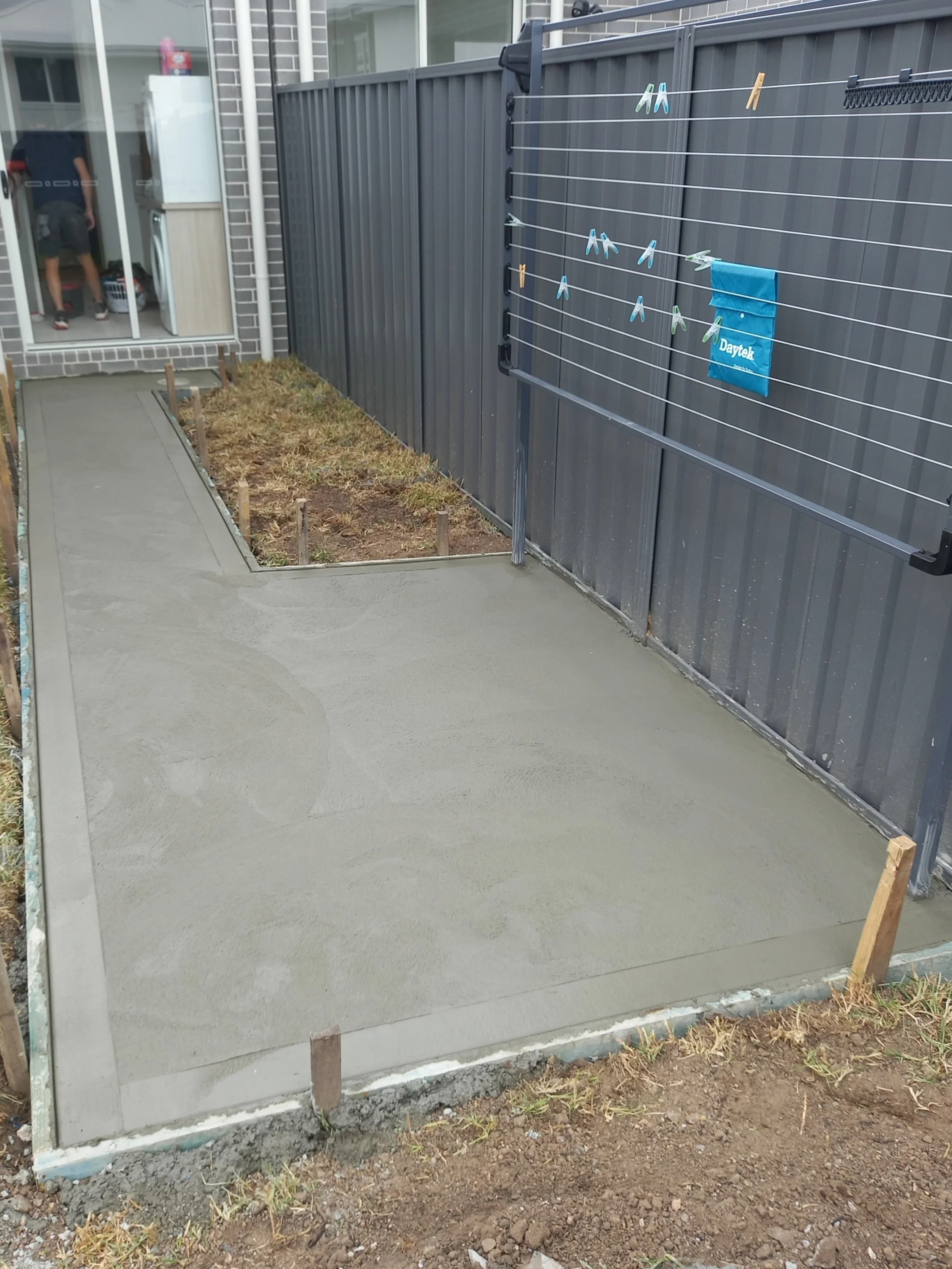 Freshly poured concrete in a backyard.