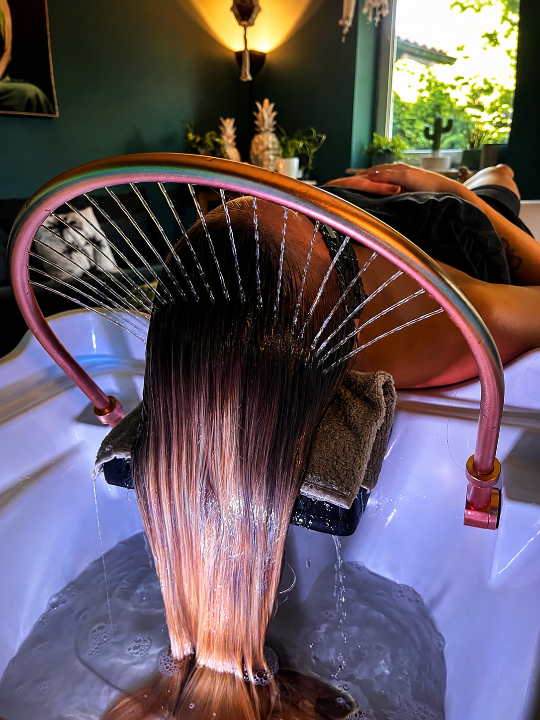 Person erhält eine Kopfmassage mit Wasser an einem Wellness- oder Spa-Ort.