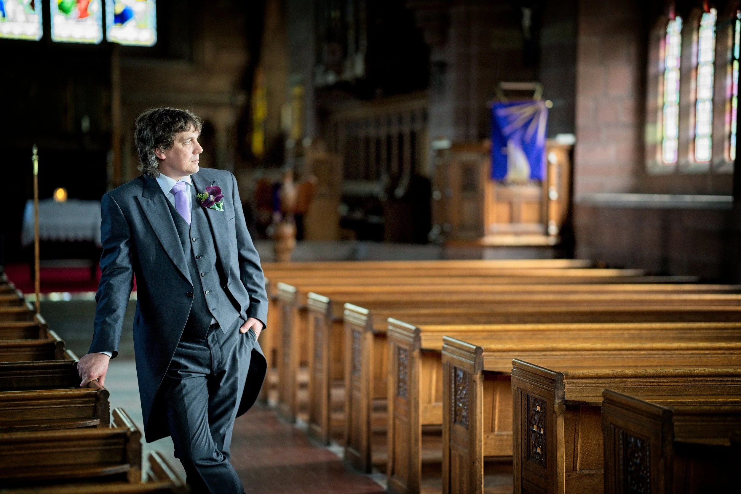Candid wedding photography capturing the  groom waiting at church in Warwickshire.