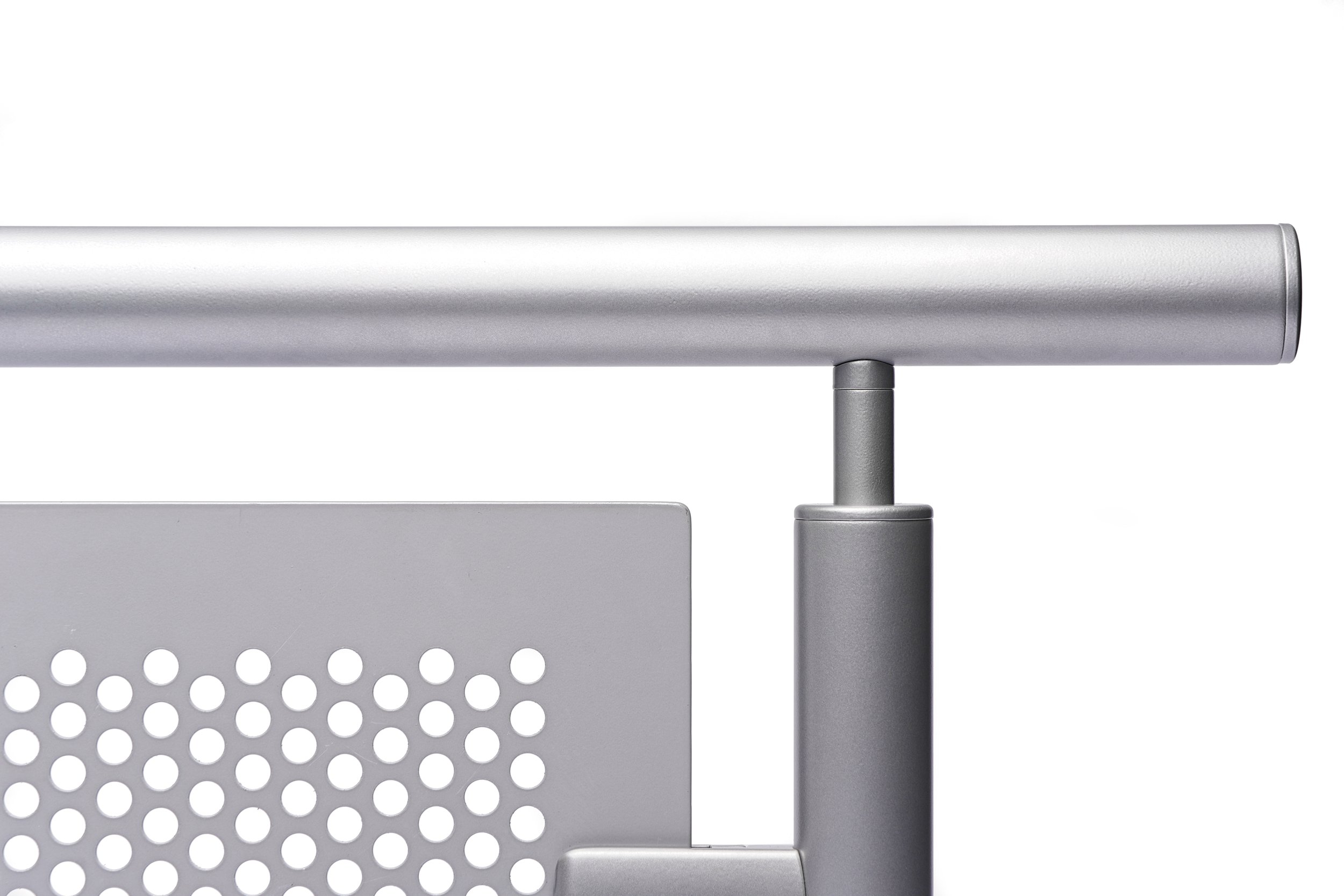 Close-up of a silver metallic metal railing with perforated panel against a plain white background. Product photography Warwickshire.