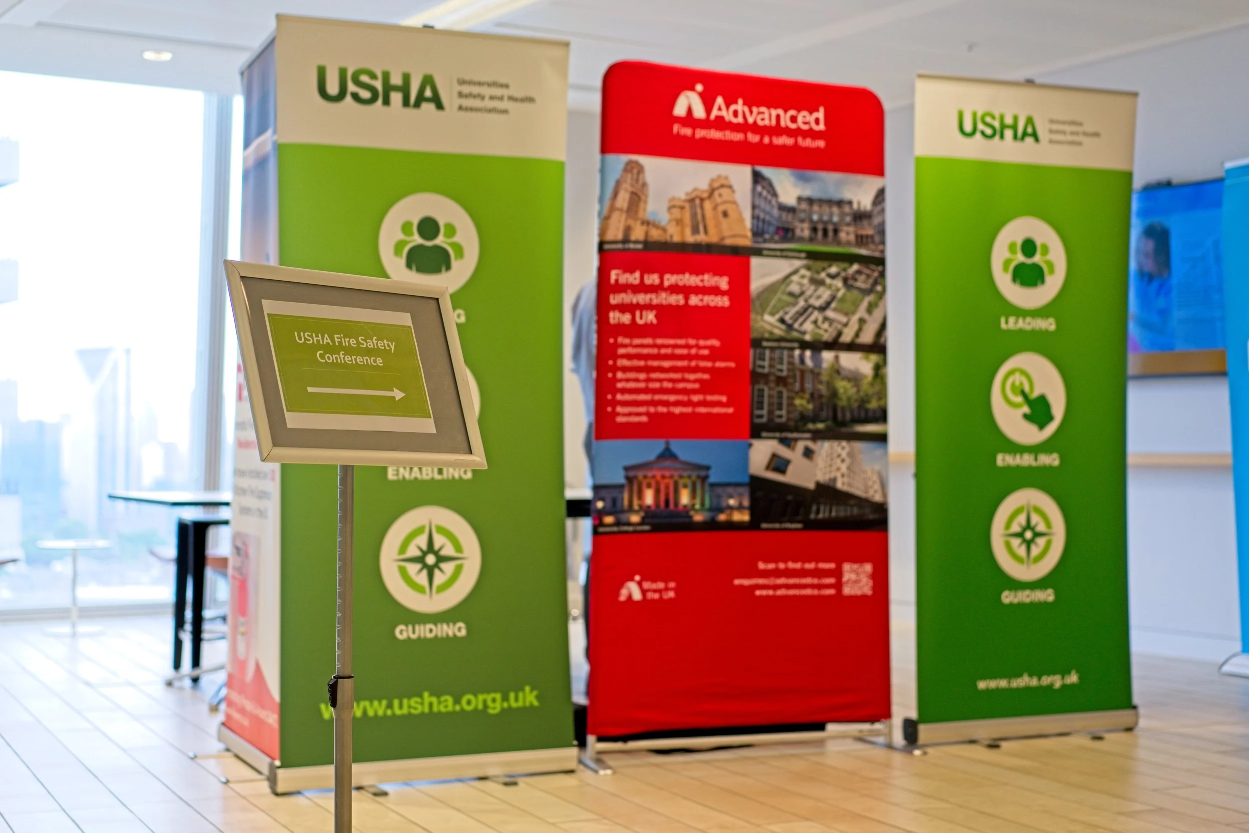 Conference setup with green and red USHA banners, and a sign for the USHA Fire Safety Conference. Event Photography by photographer based in Southam, Warwickshire.