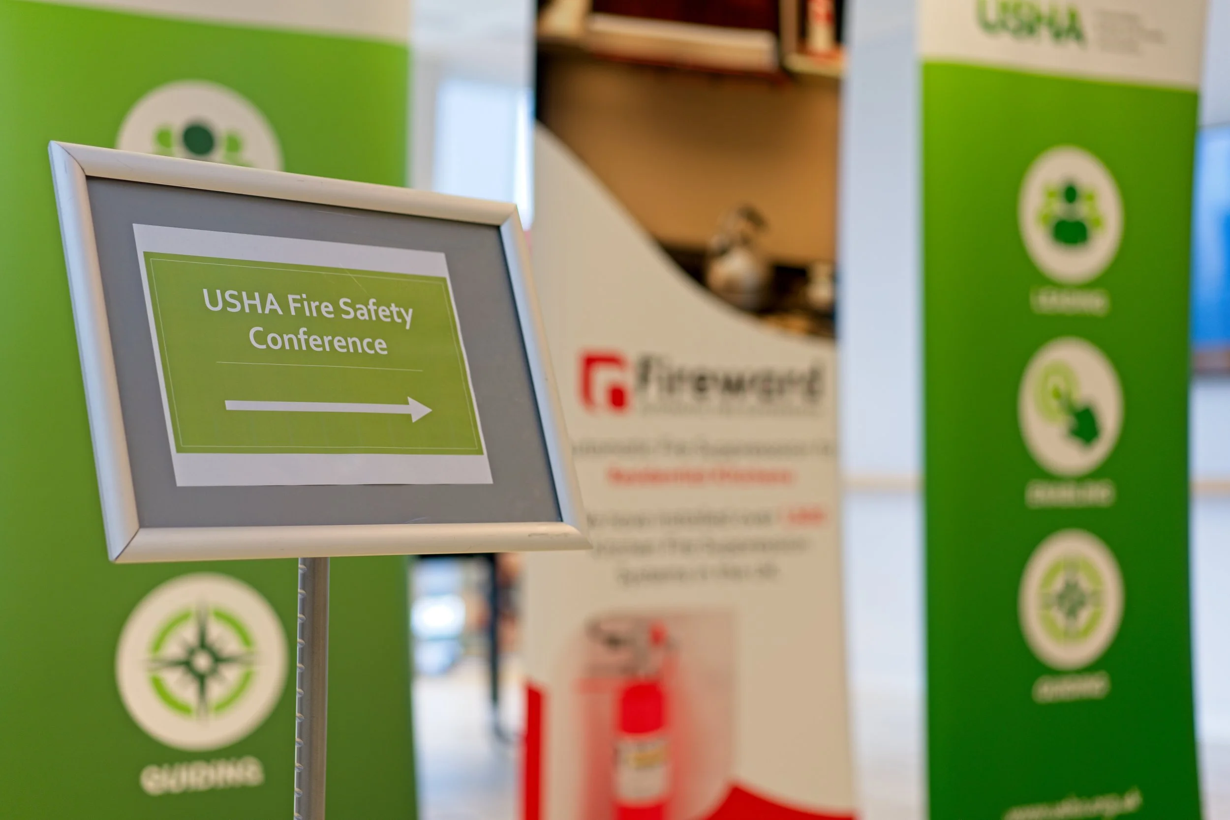 Sign indicating the direction to the USHA Fire Safety Conference with an arrow pointing right. Event Photography by photographer based in Southam, Warwickshire.