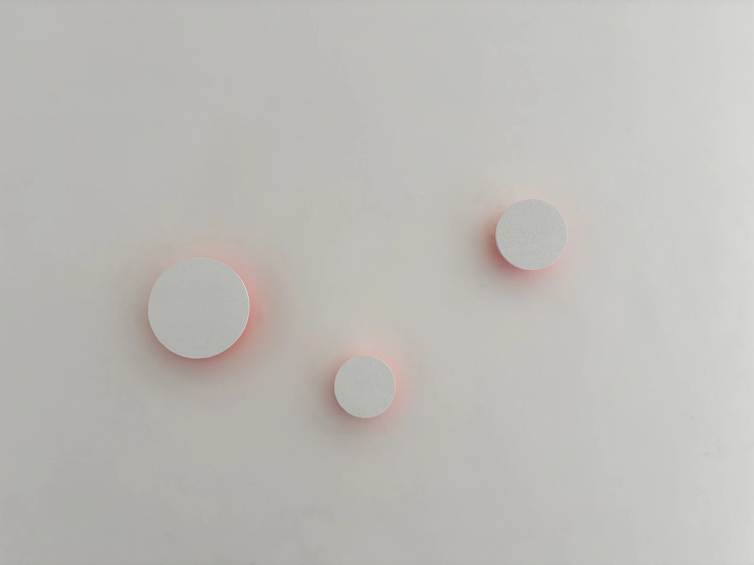 Sei cerchi bianchi con contorno rosa su uno sfondo grigio chiaro.