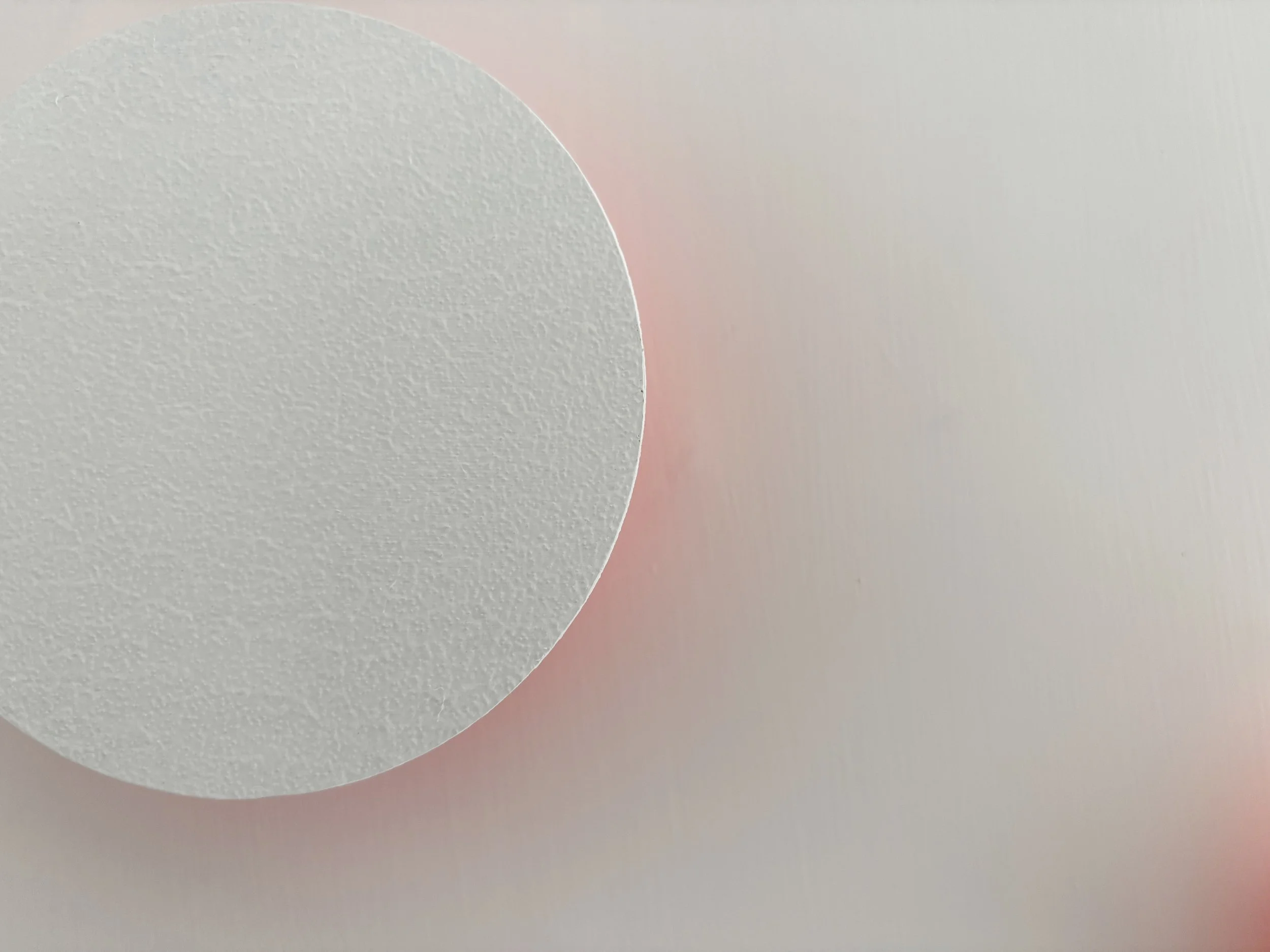 Immagine di una palla bianca su uno sfondo bianco con una sfumatura rosa.