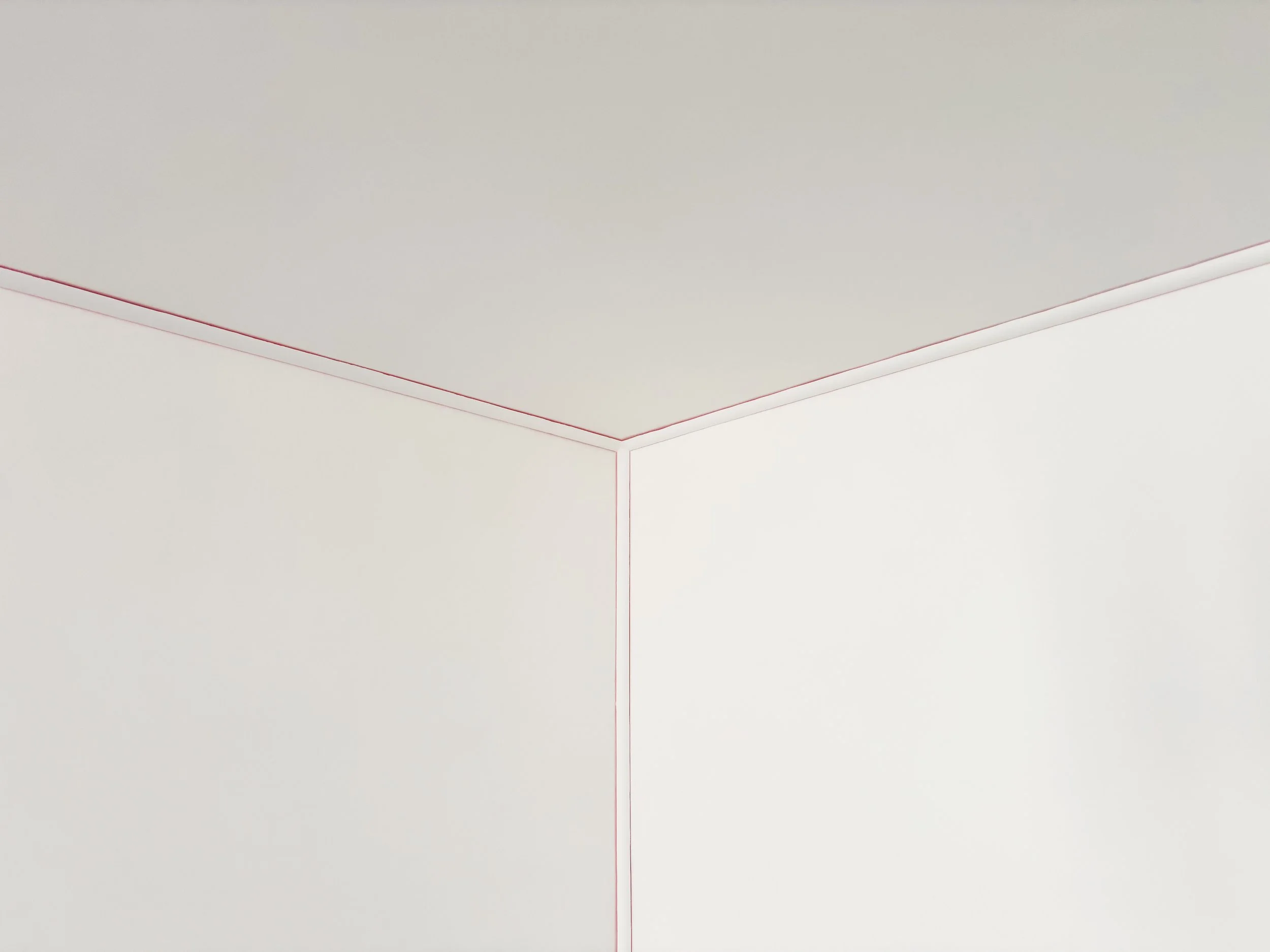 Angolo di soffitto bianco con linee decorative rosse lungo i bordi.