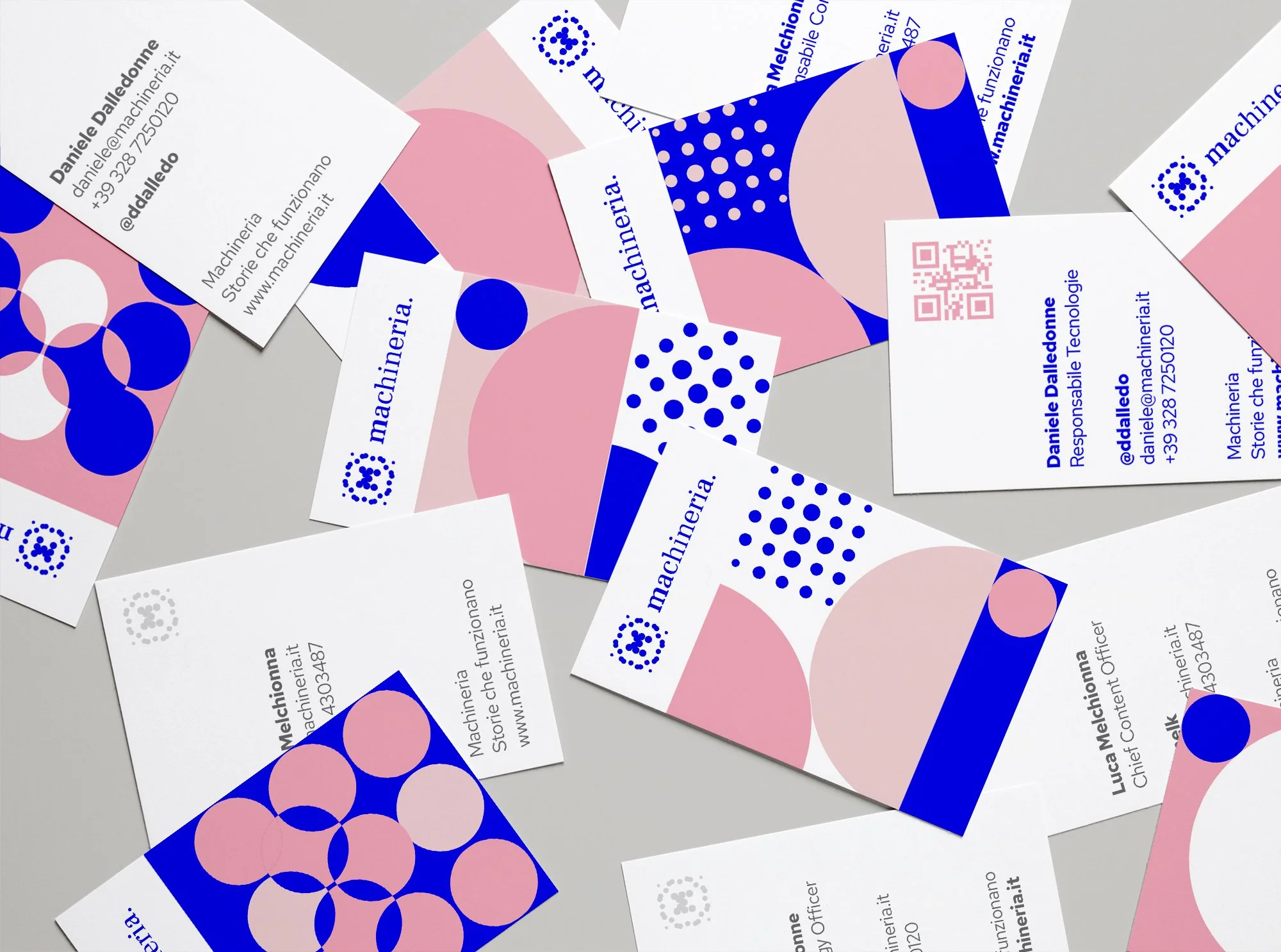 Carte da visita con design moderno in colori rosa, blu e bianco, contenenti testi, numeri di telefono, indirizzo email e logo aziendale.