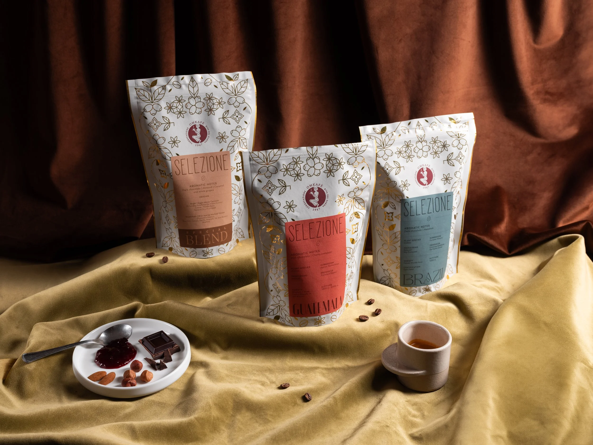 confezioni di caffe omkafe selezione fotografate in un ambiente elegante con una luce che risalta i dettagli dorati del packaging