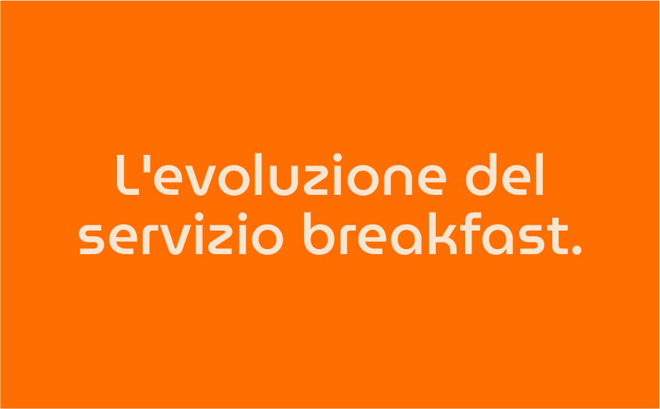 Testo in italiano su uno sfondo arancione che dice 'L'evoluzione del servizio breakfast.'