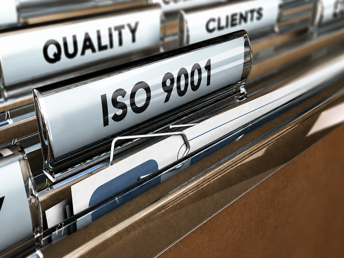 File folders in a filing cabinet with labels, including ISO 9001, quality, and clients.