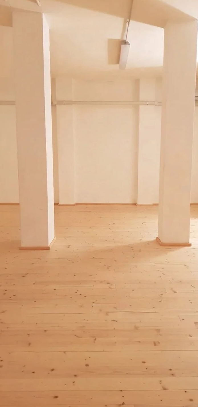 Stella 35 a Brescia-. Sede di corsi yoga, flamenco. meditazione costellazioni familiari. Interno di un'ampia stanza vuota con pareti chiare, pavimento in legno e strutture di supporto.
