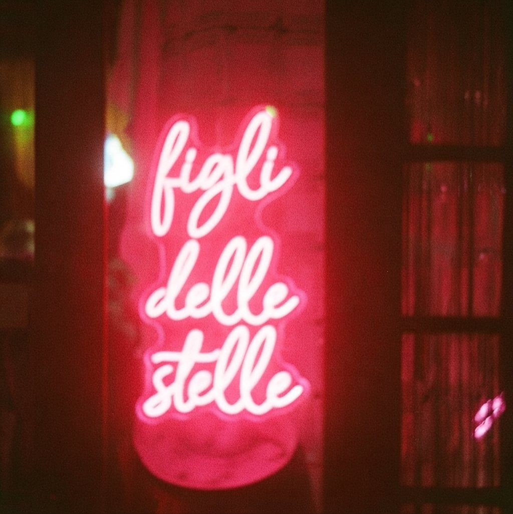 scritta neon rosa che dice 'figli delle stelle' a Casa delle Stelle, ambiente e associazione queer a Brescia