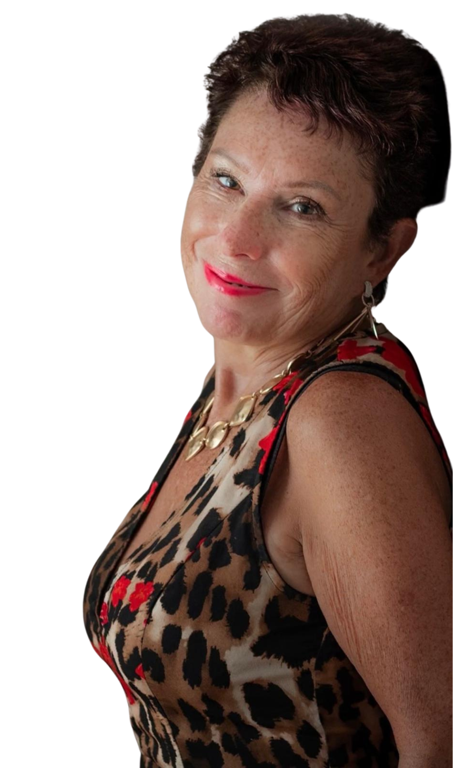 Julie Brooker with short dark hair, wearing a sleeveless animal print top with red accents, a gold necklace, and earrings, against a plain white background.