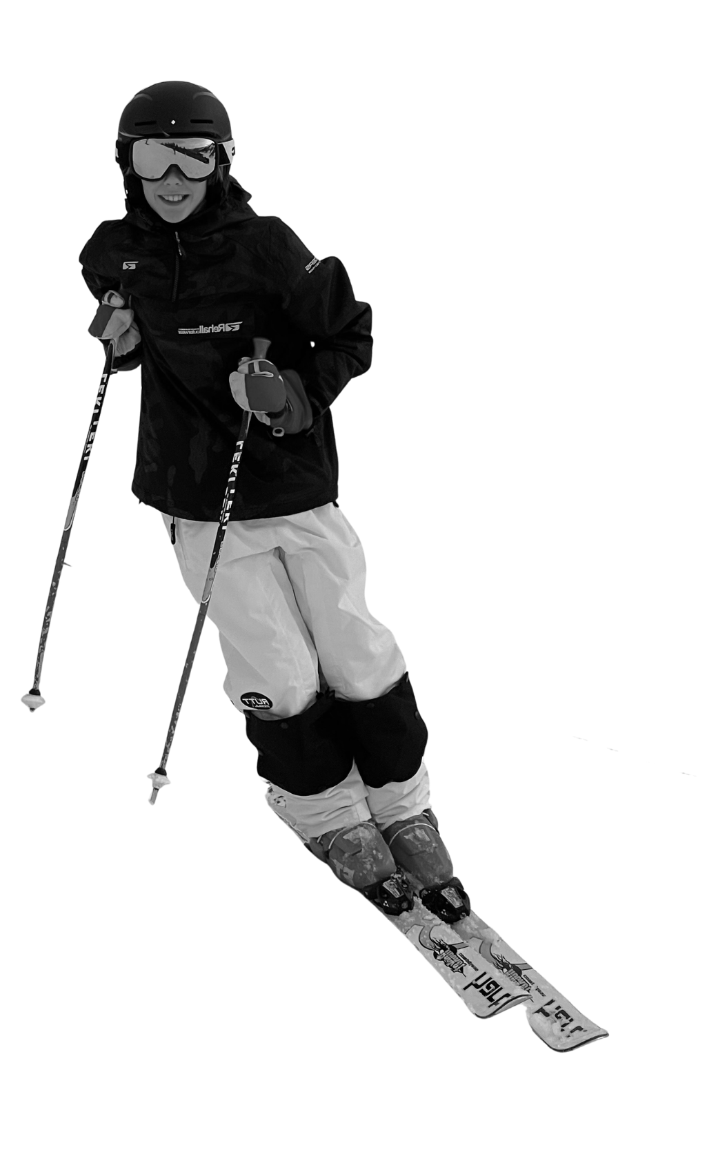 Young girl dressed in ski gear, wearing a helmet and goggles, holding ski poles, posed on skis.