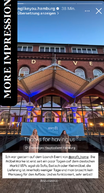 Image shows the exterior of a brick building with a large canopy covering an outdoor seating area at a launch event in Hamburg, Germany, with event lighting and two women sitting at a table.