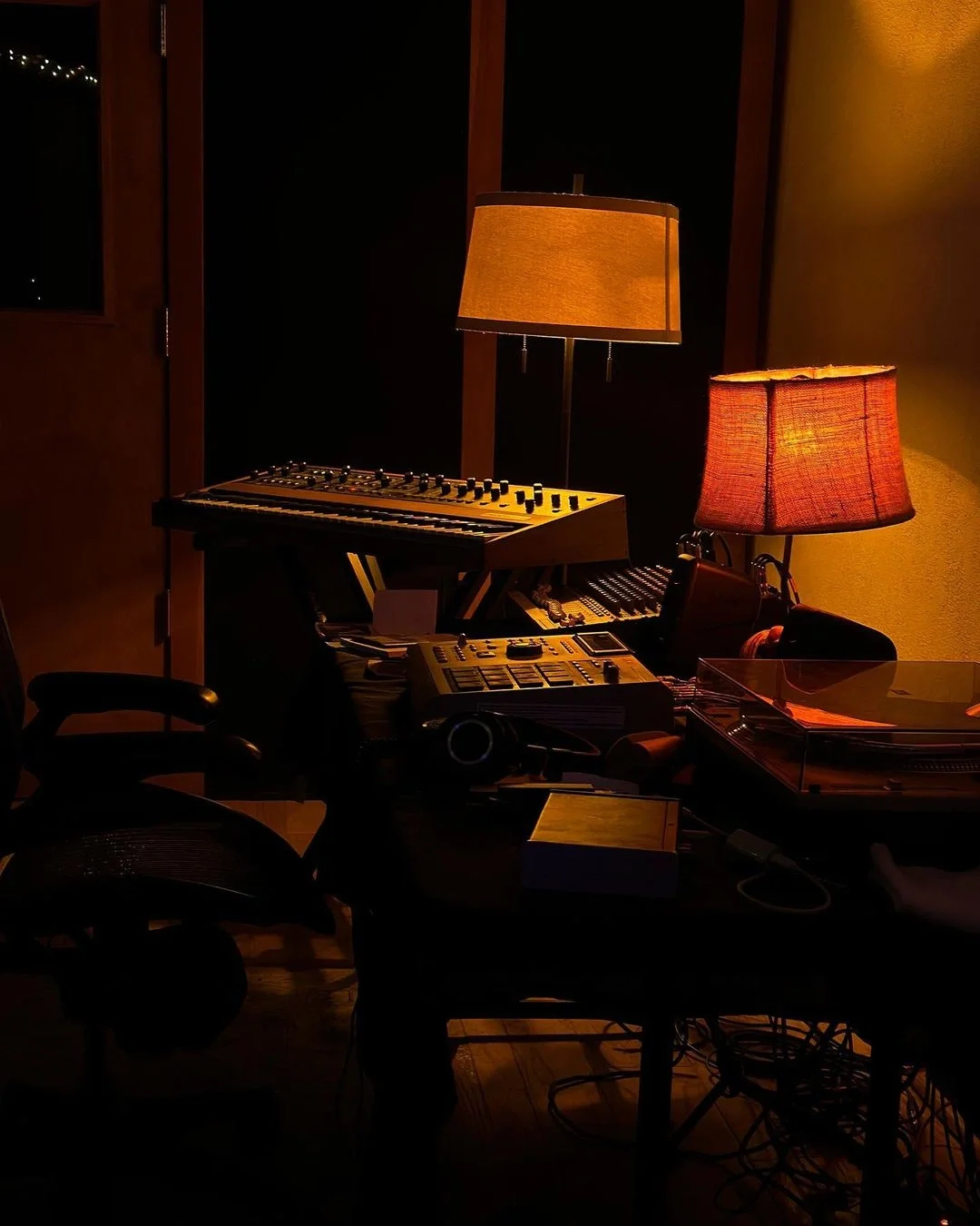 Synthesiser and music production equipment in Sounwave's warmly lit studio.
