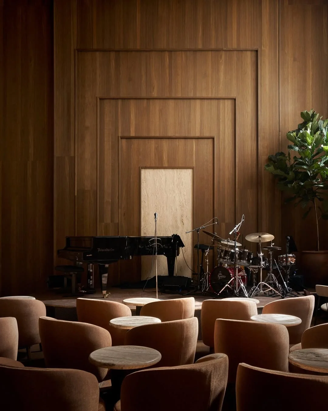Piano and drum kit in a warm timber-lined music room at Epicurus, Copenhagen.