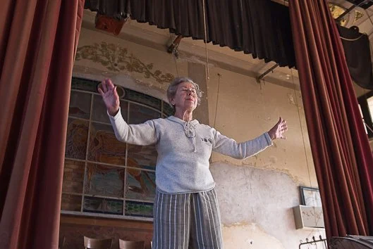 Una donna sul palcoscenico del Teatro Marinoni