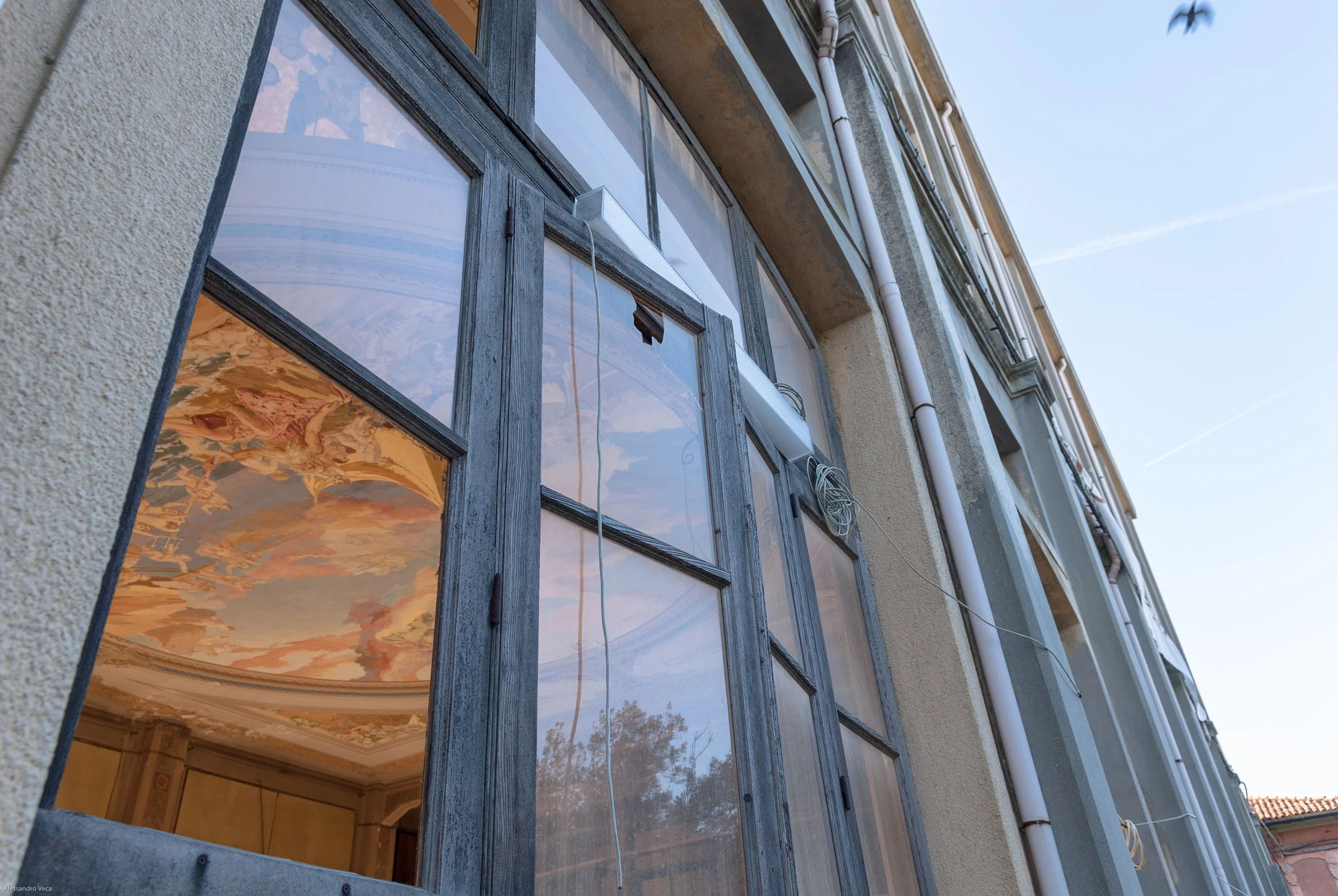 Facciata vetrata del Teatro Marinoni con riflesso del soffitto dipinto e dell’architettura interna
