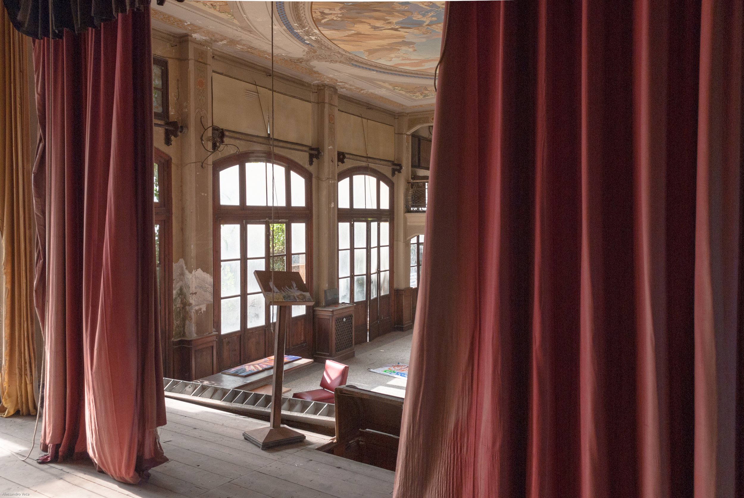 Palcoscenico del Teatro Marinoni incorniciato dai grandi sipari rossi e dalle finestre del Lido