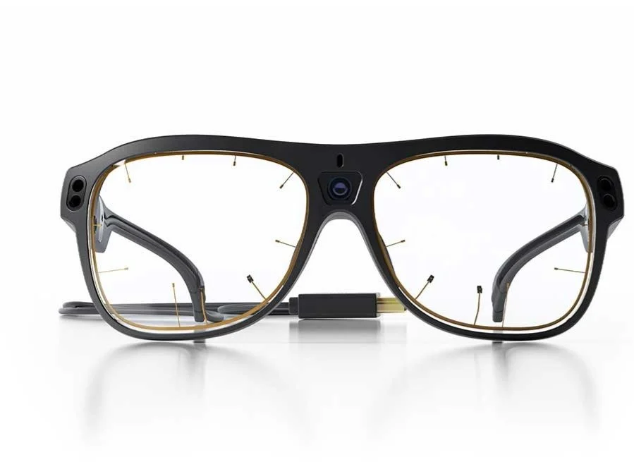 A pair of black and gold smart glasses with a built-in camera in the center.