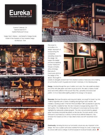 Interior of a craft brewery or taproom, featuring a bar area with bar stools, hanging pendant lights, and framed artwork on the walls.