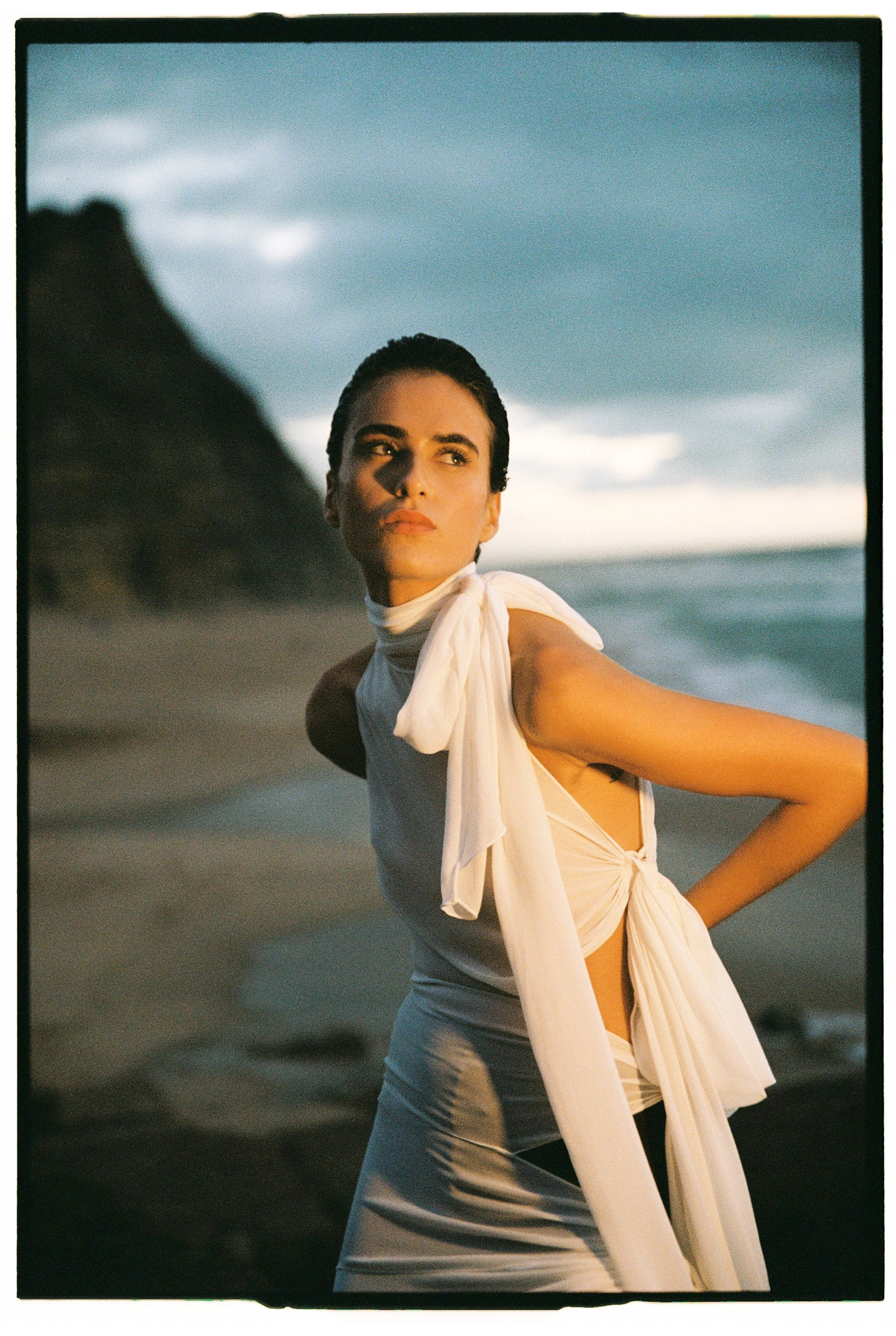 model wearing alaia white dress at the beach in lisbon