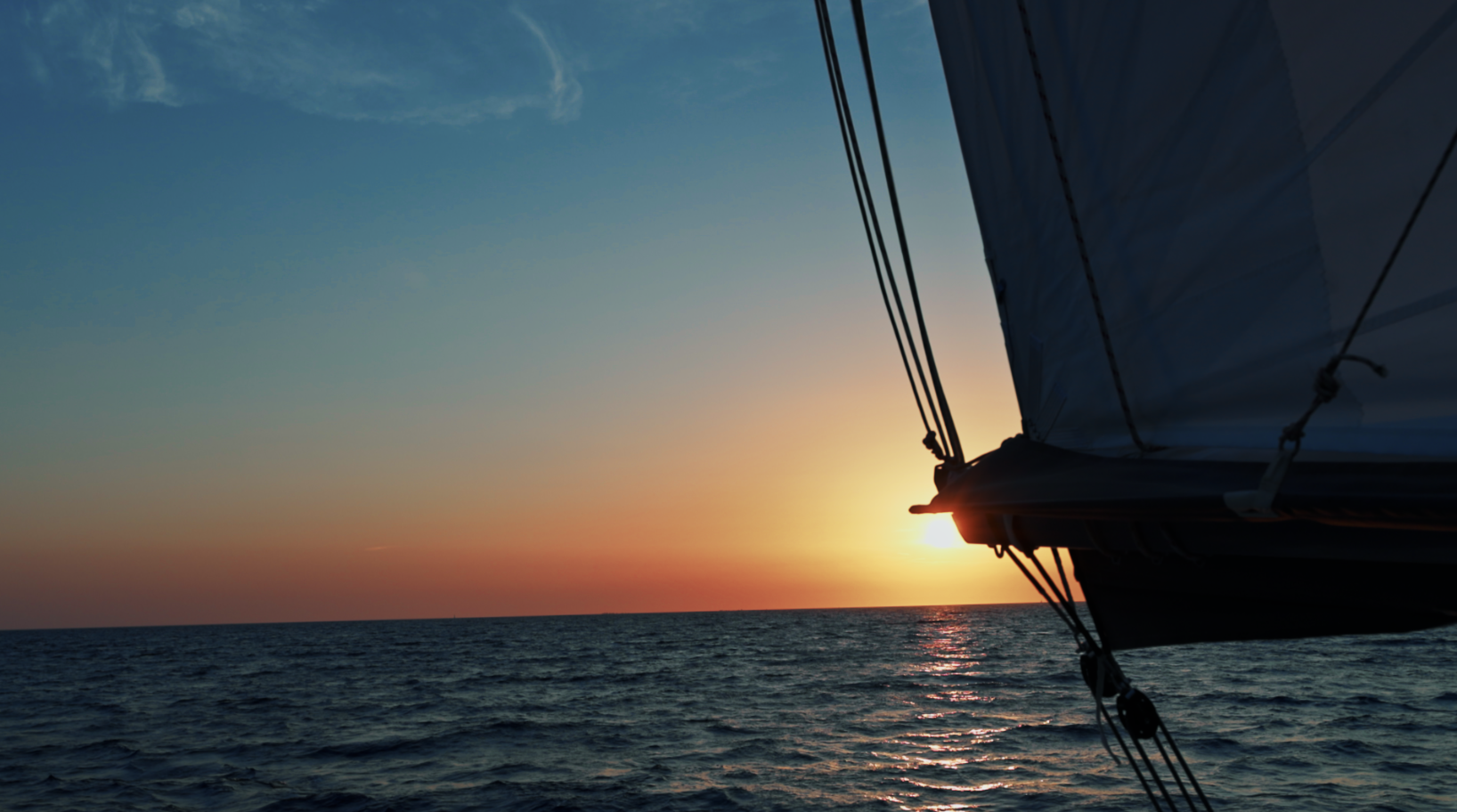 Coucher de soleil sur l'océan filmé depuis le pont d'un voilier, vidéo outdoor et nautique