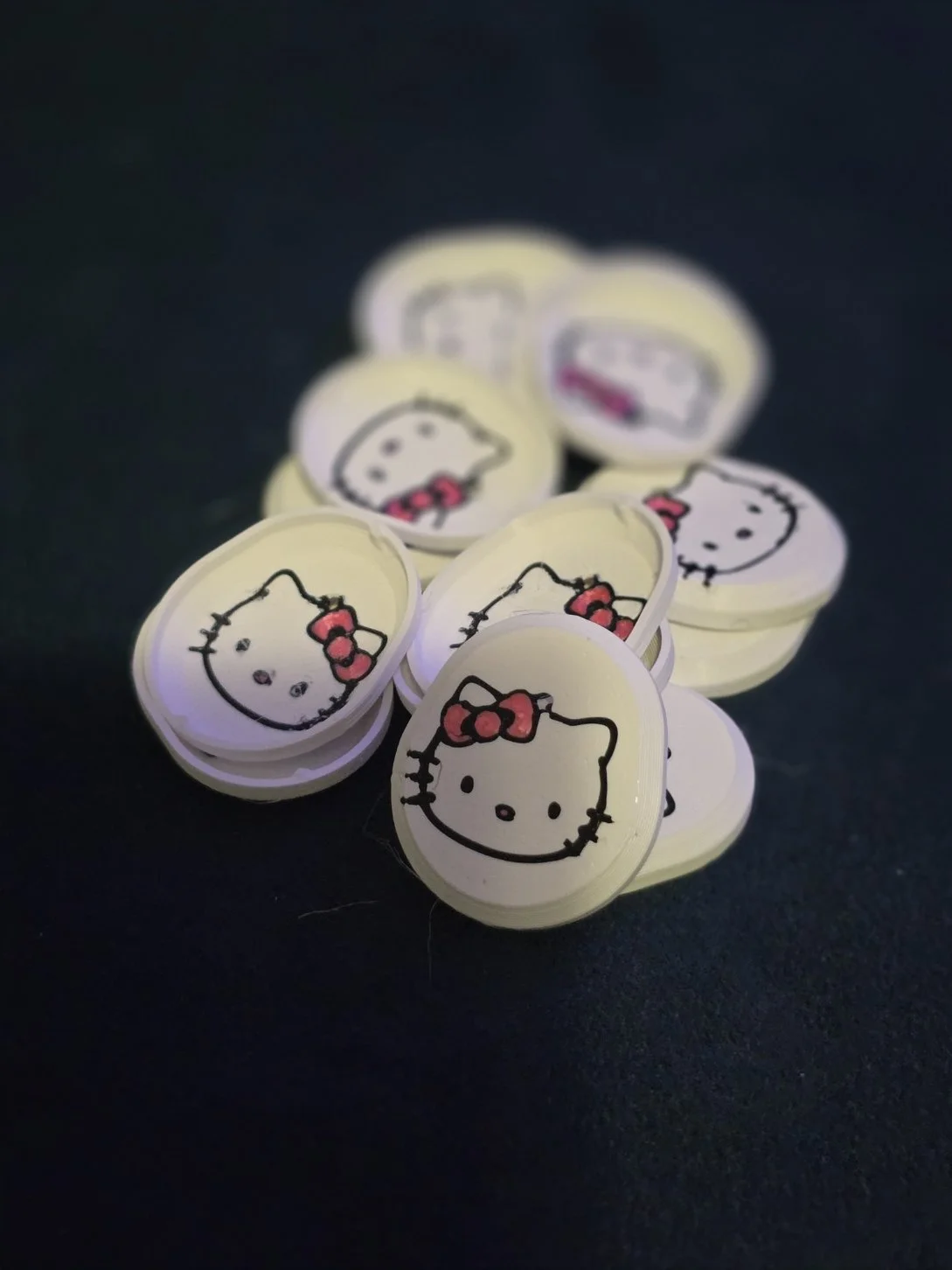 Collection of small circular stickers featuring the Hello Kitty character with a red bow on her head.