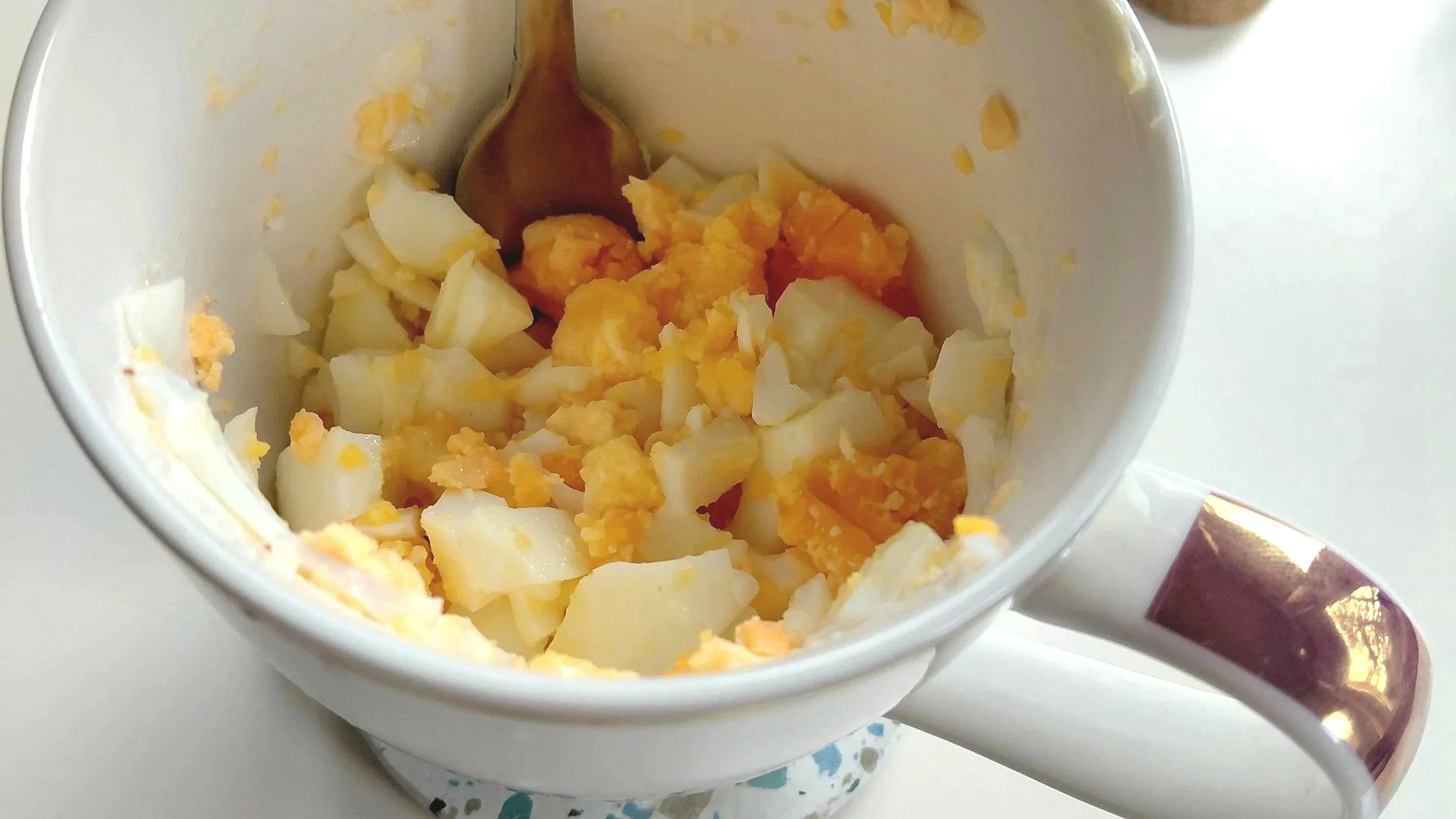 Boiled egg, mashed up in a mug